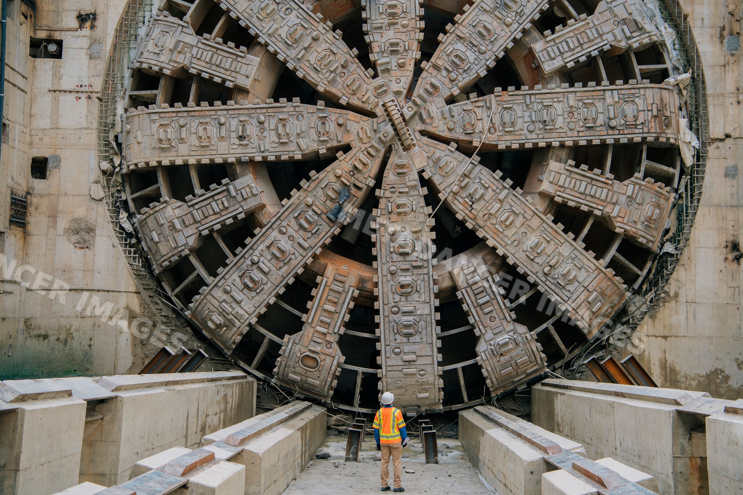 A construction white worker inspects a tunnel boring machine