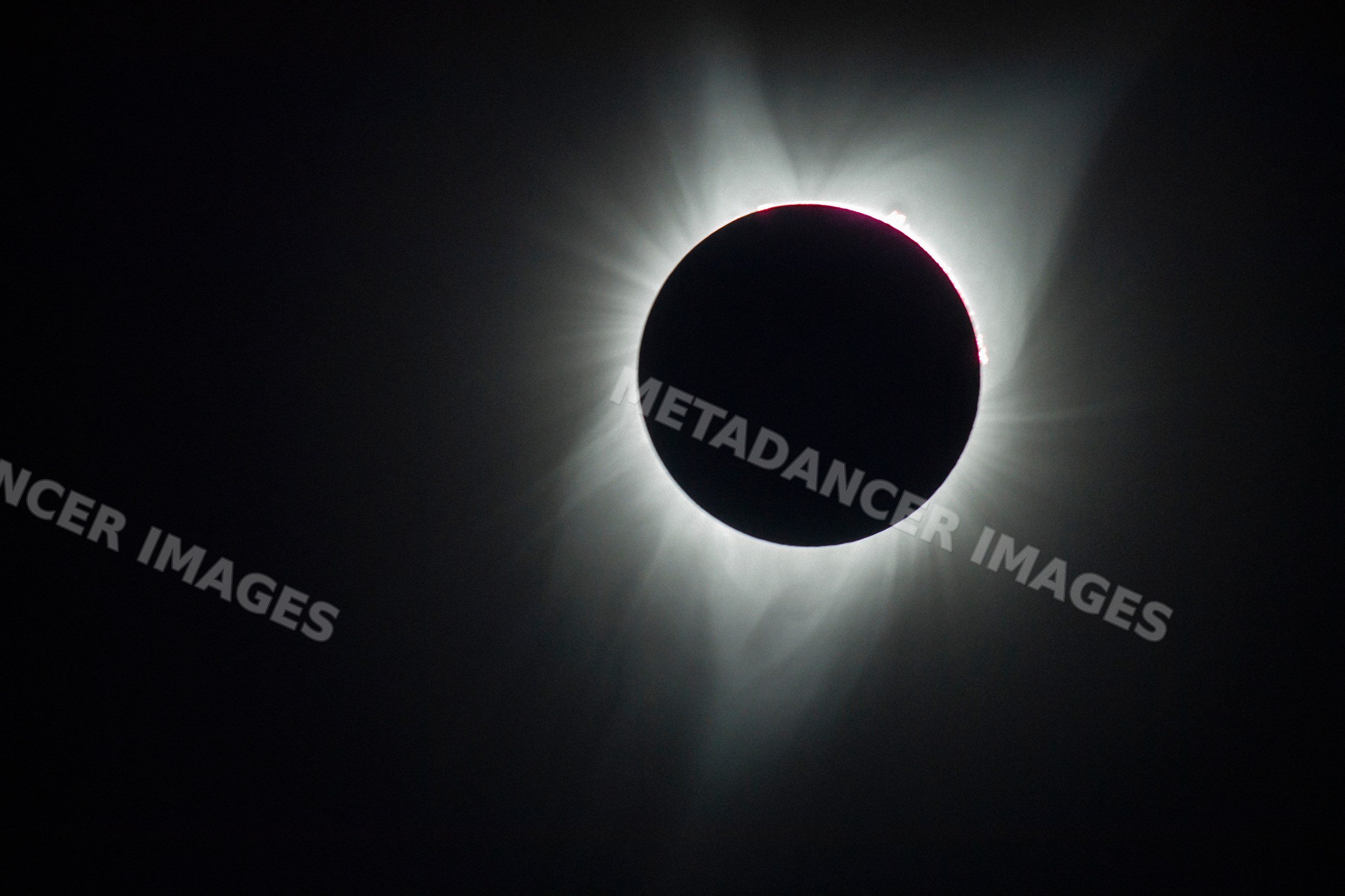 Solar eclipse with sun corona visible over dark sky