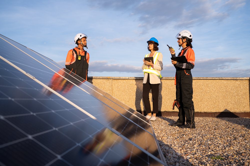 Technicians inspecting solar panels on rooftop in Madrid, Spain
