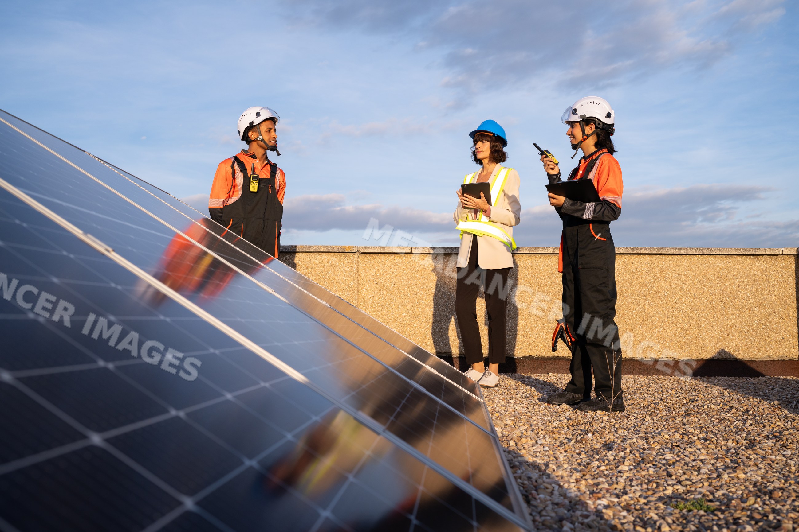 Technicians inspecting solar panels on rooftop in Madrid, Spain