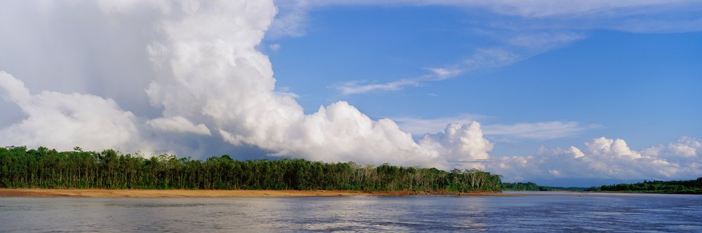 River and tropical forest under dramatic clouds