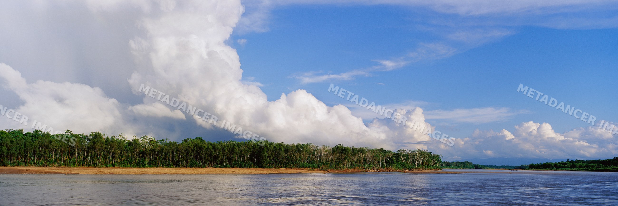 River and tropical forest under dramatic clouds