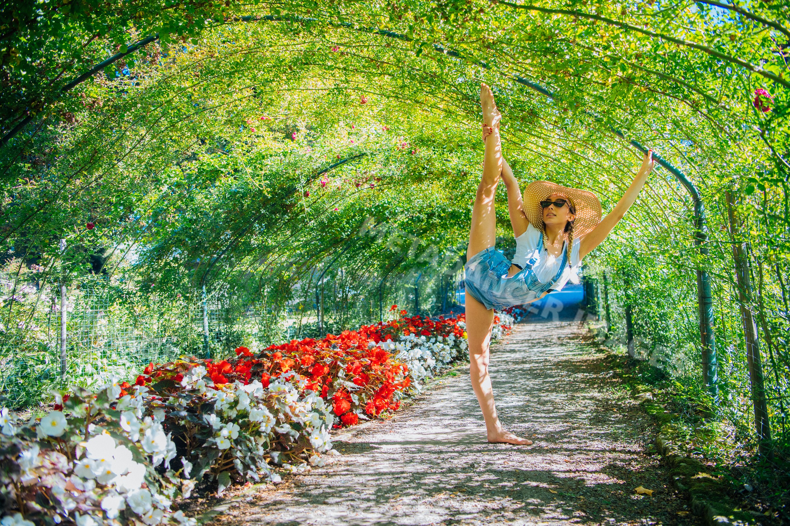 White woman stretching in flower tunnel in Tacoma garden