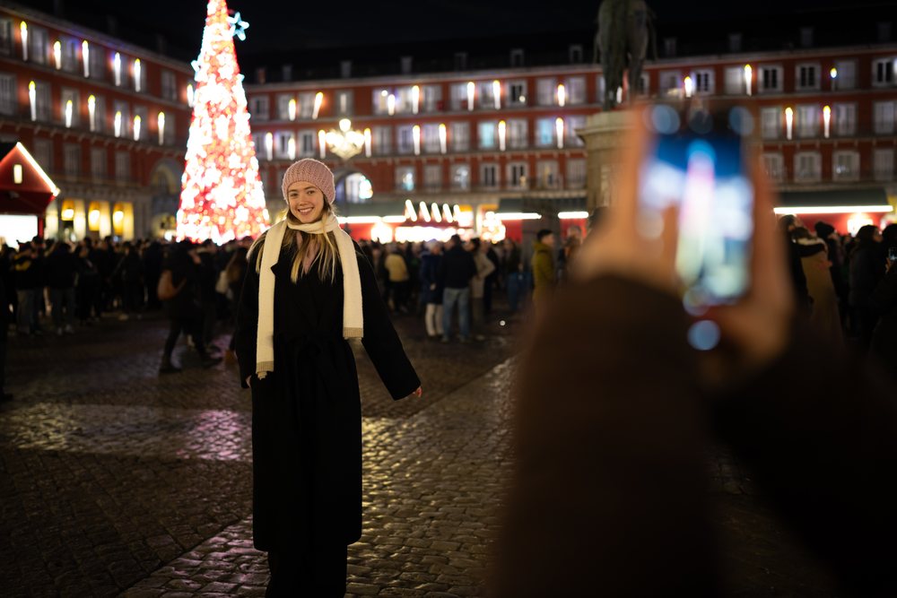 White woman posing by illuminated christmas tree