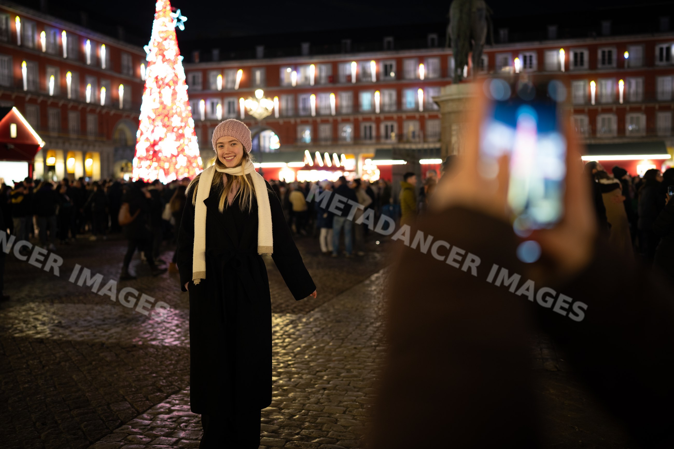 White woman posing by illuminated christmas tree