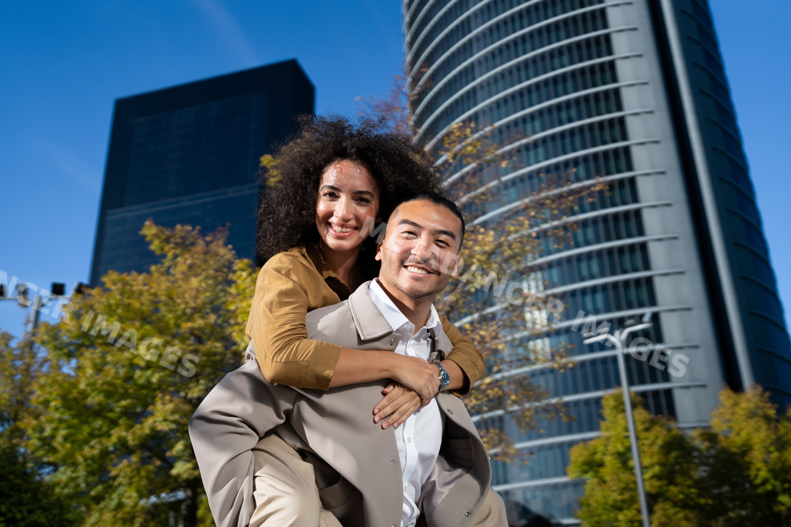 Man giving piggyback ride to woman outdoors in urban setting