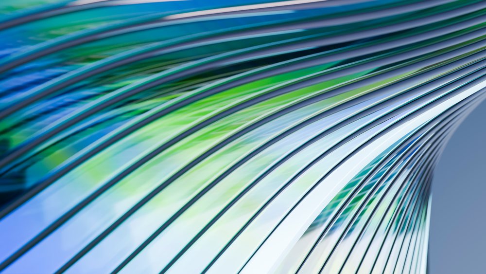Abstract modern architecture with curved glass panels reflecting blue