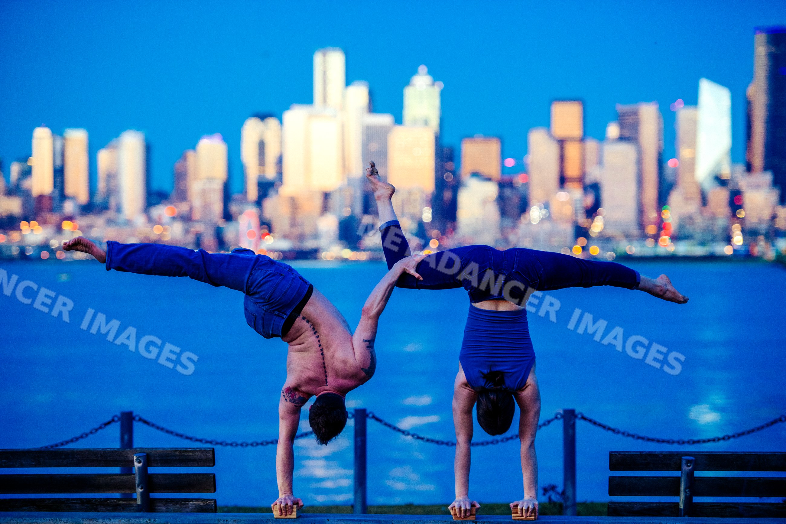 Partner acrobatics handstands with Seattle city skyline waterfront