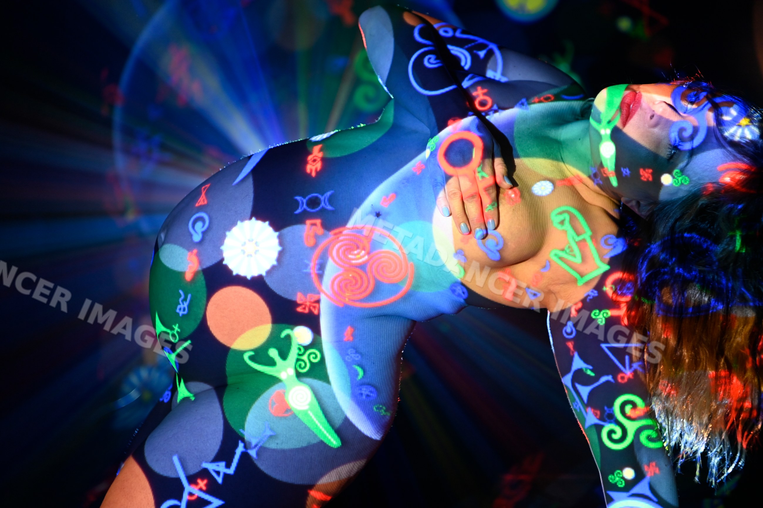 Female nude body with colorful symbolic projections and artistic light