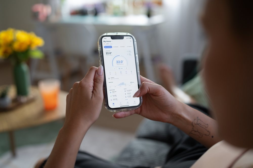 White Person adjusts temperature on smart home thermostat application