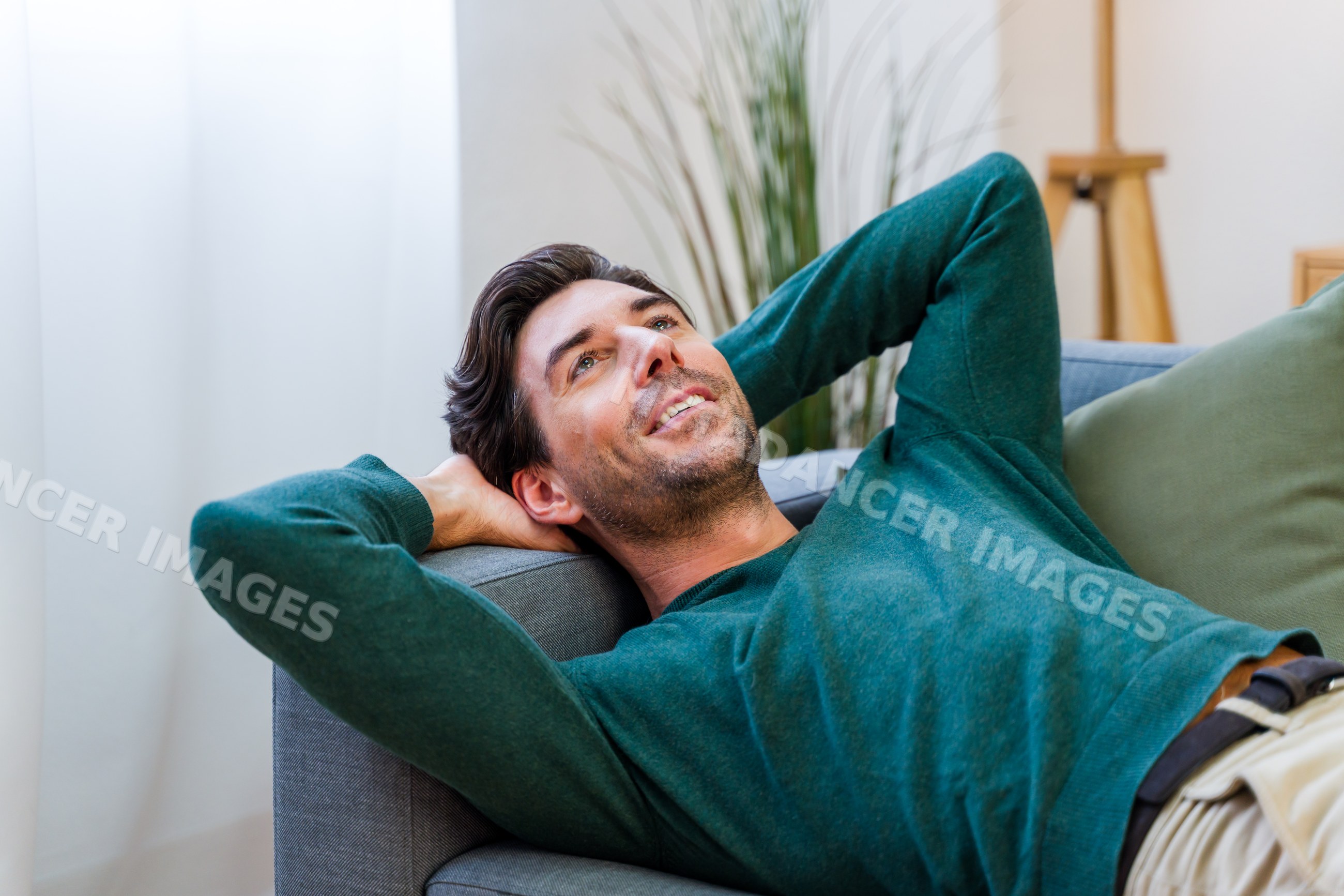 White man relaxing on couch in comfortable living room interior