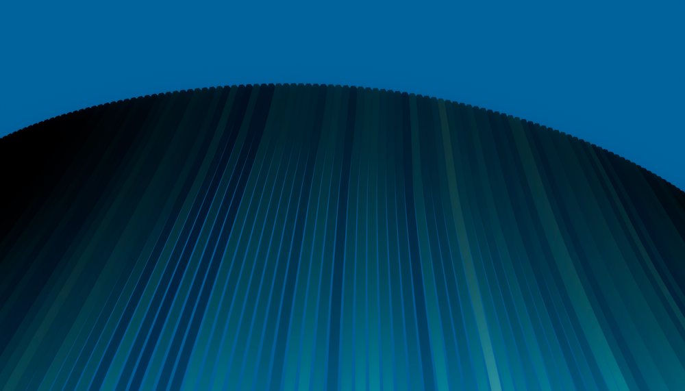 Curved modern building with vertical metal facade under blue sky