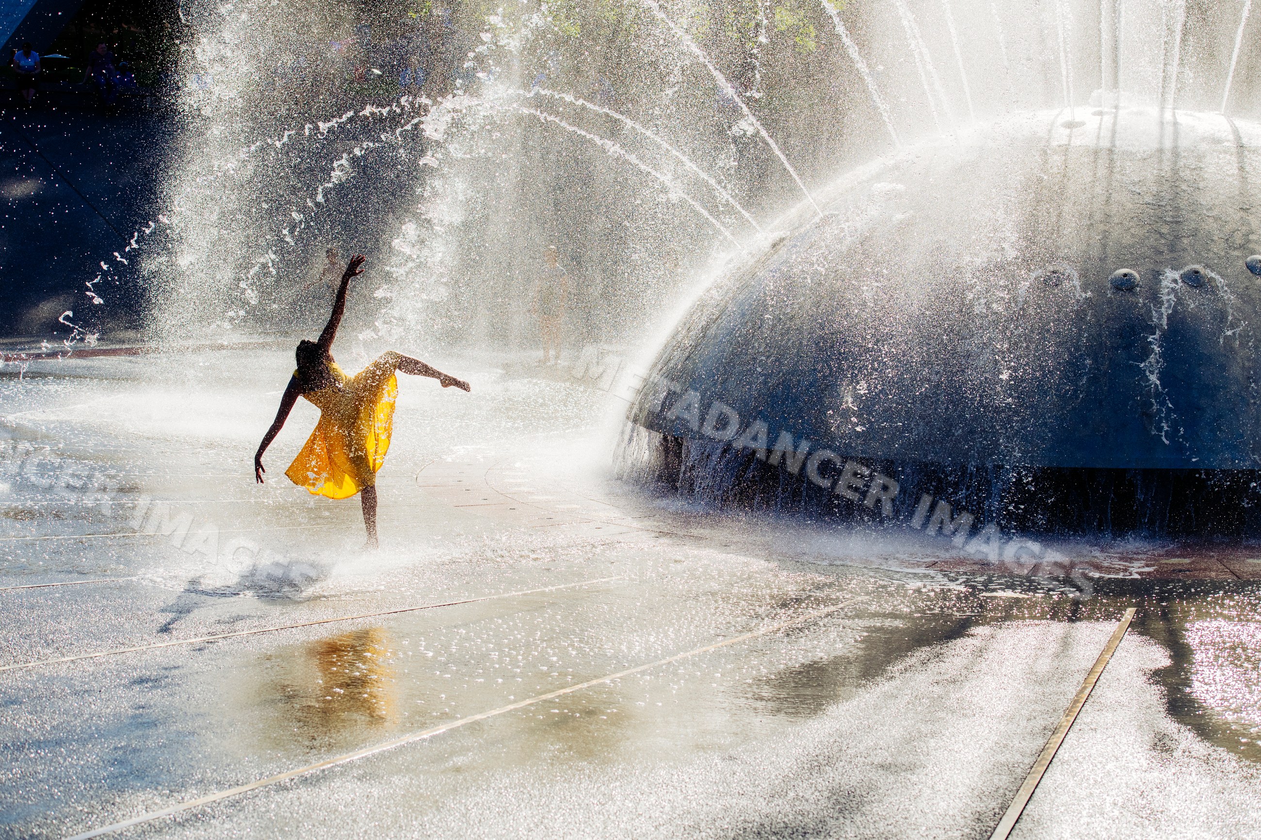 South Asian dancer performing in water fountain spray outdoors