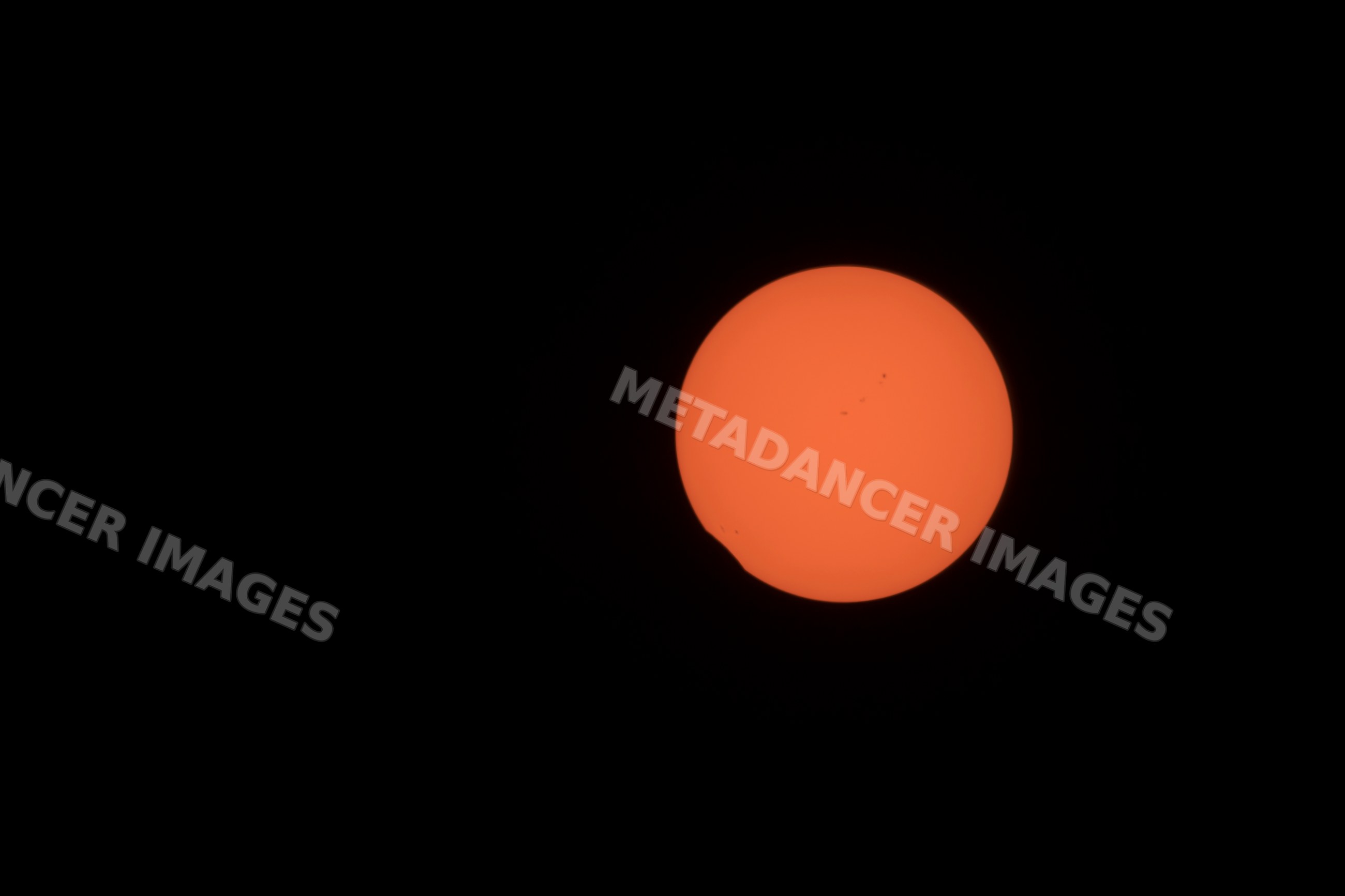 Partial solar eclipse with sunspots in the sky