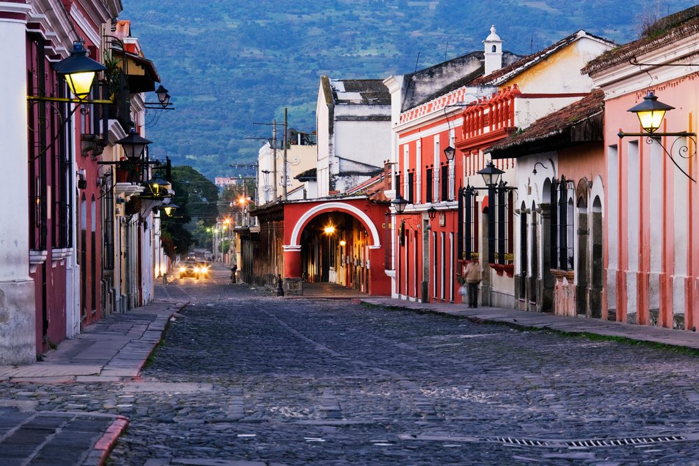 Cobblestone street with colonial buildings and lit lamps in antigua