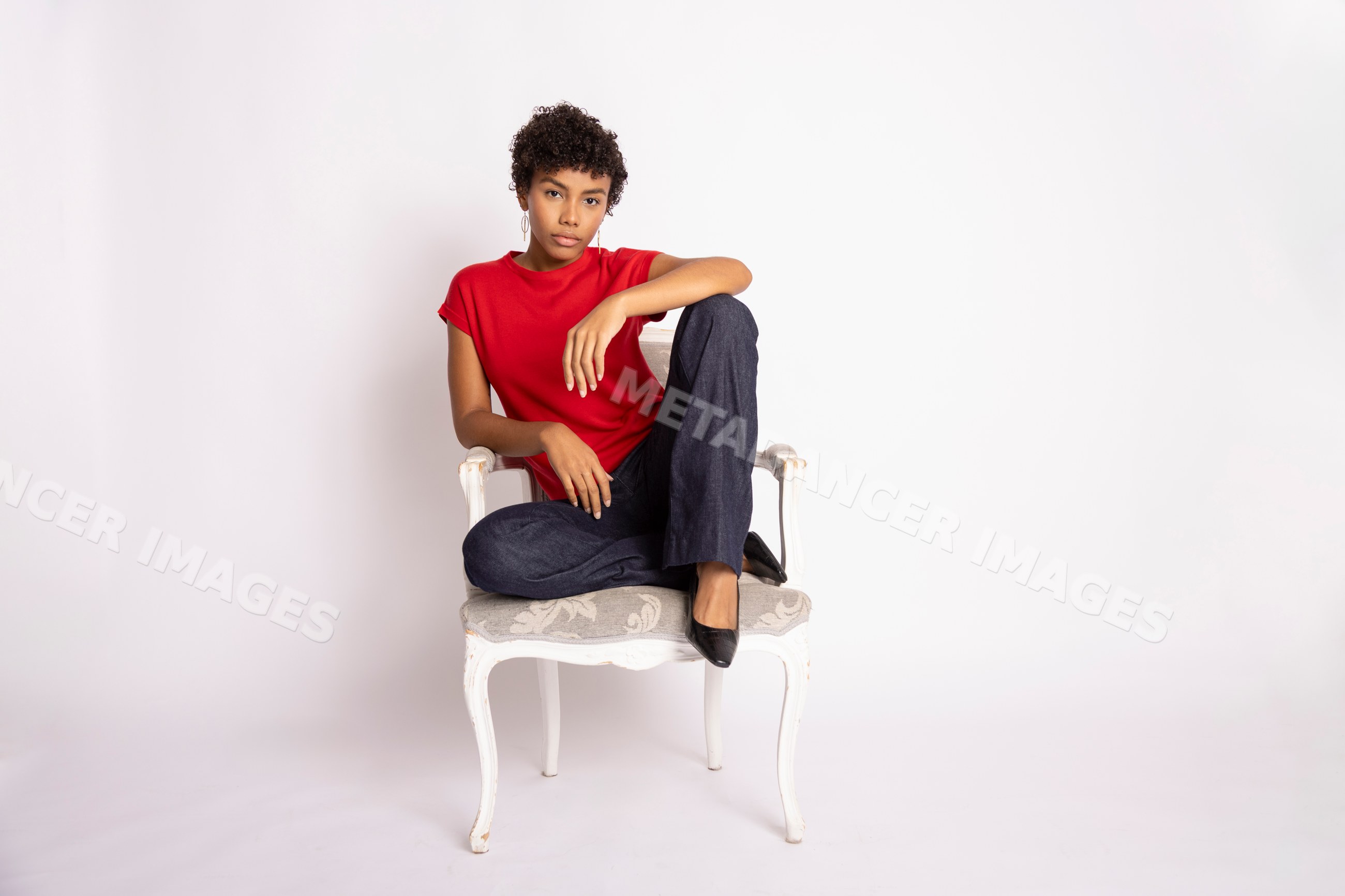 Hispanic woman sitting on white decorative chair
