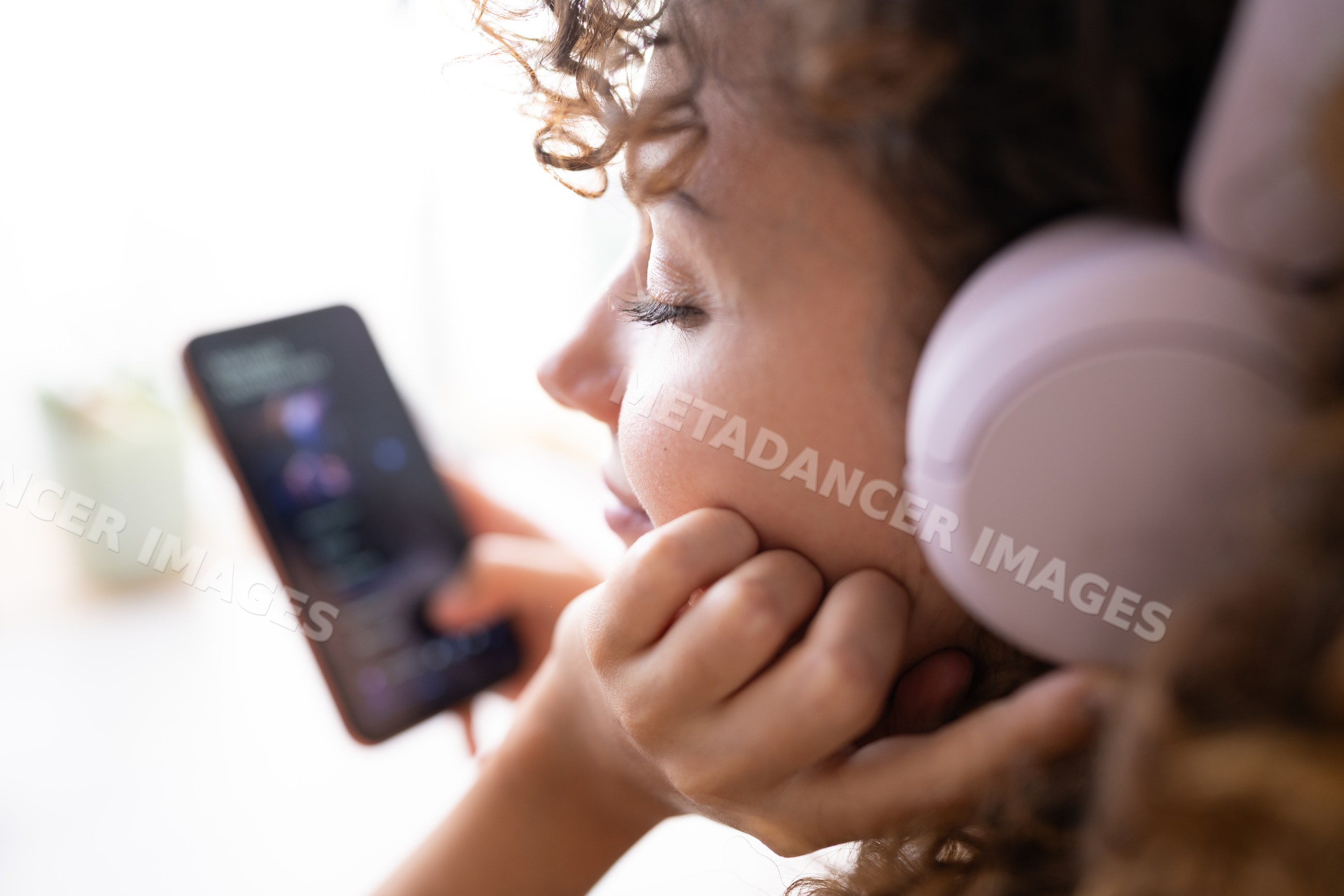 White woman listening to music with headphones at home in Spain