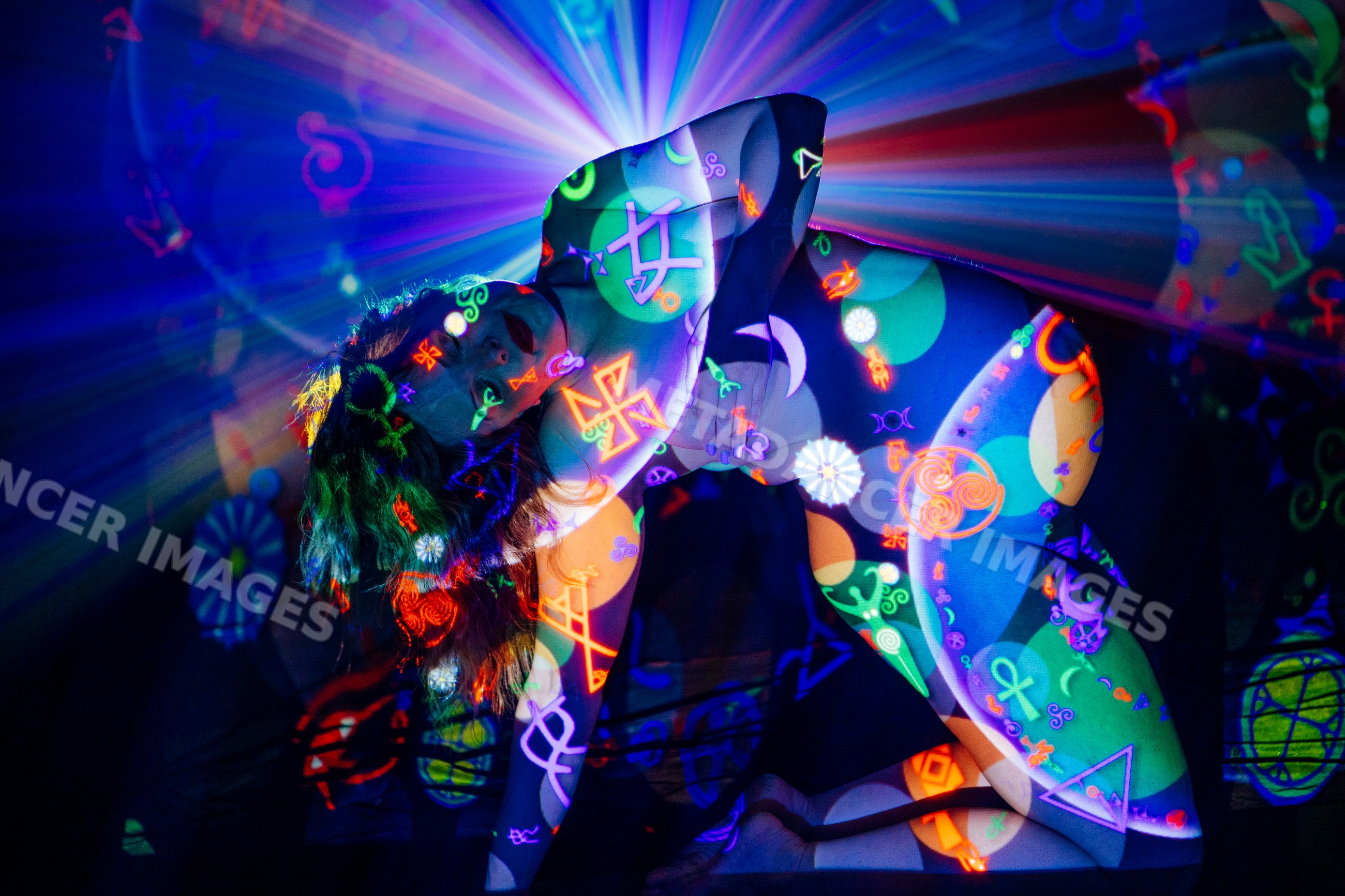 White woman kneeling with neon symbol projections