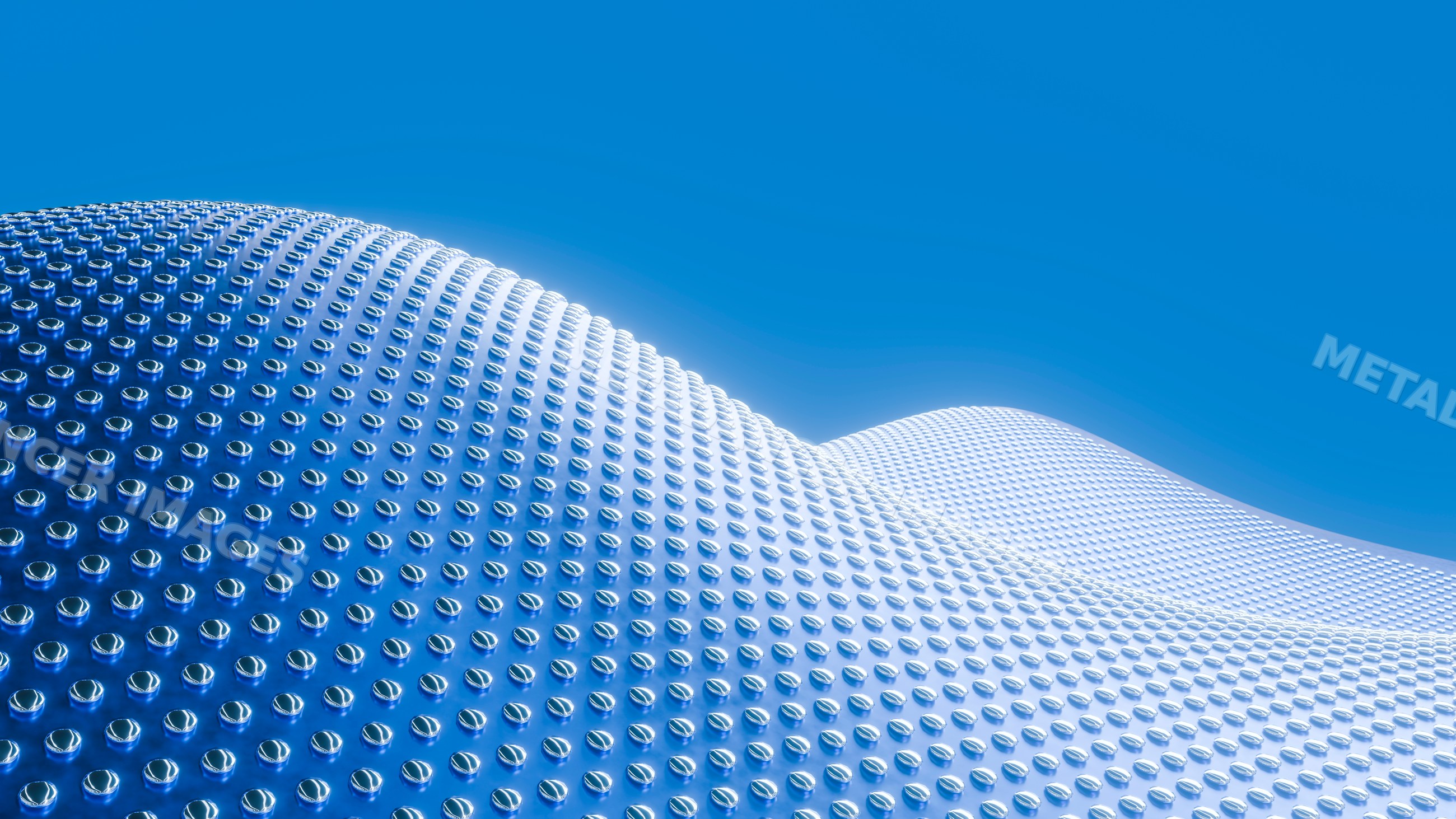 Curved reflective metal surface with round studs under blue sky