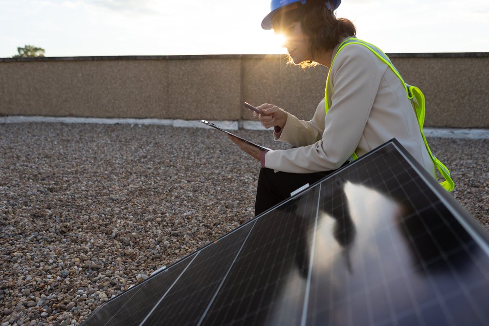 White woman inspecting solar panel on rooftop in Madrid Spain