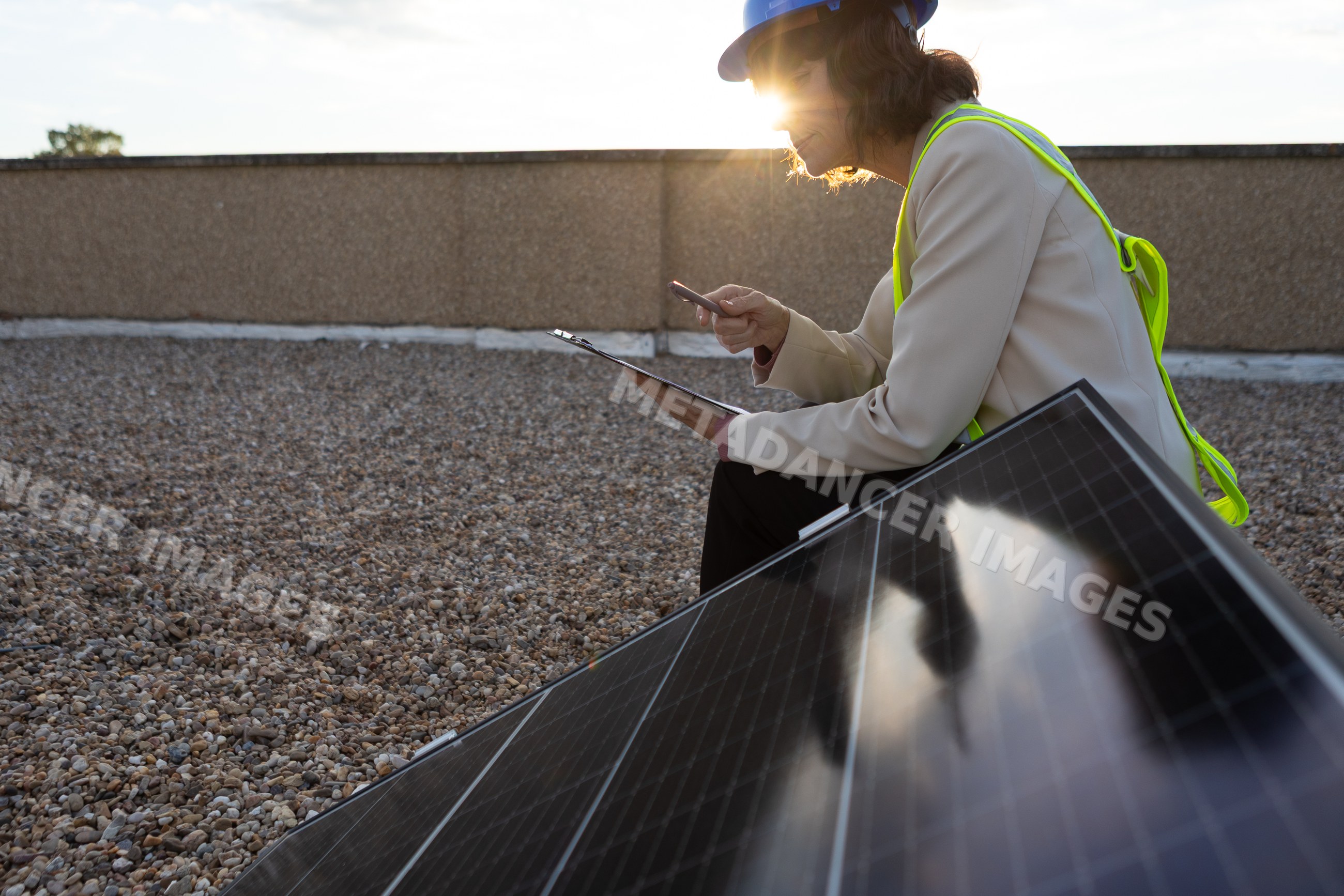 White woman inspecting solar panel on rooftop in Madrid Spain