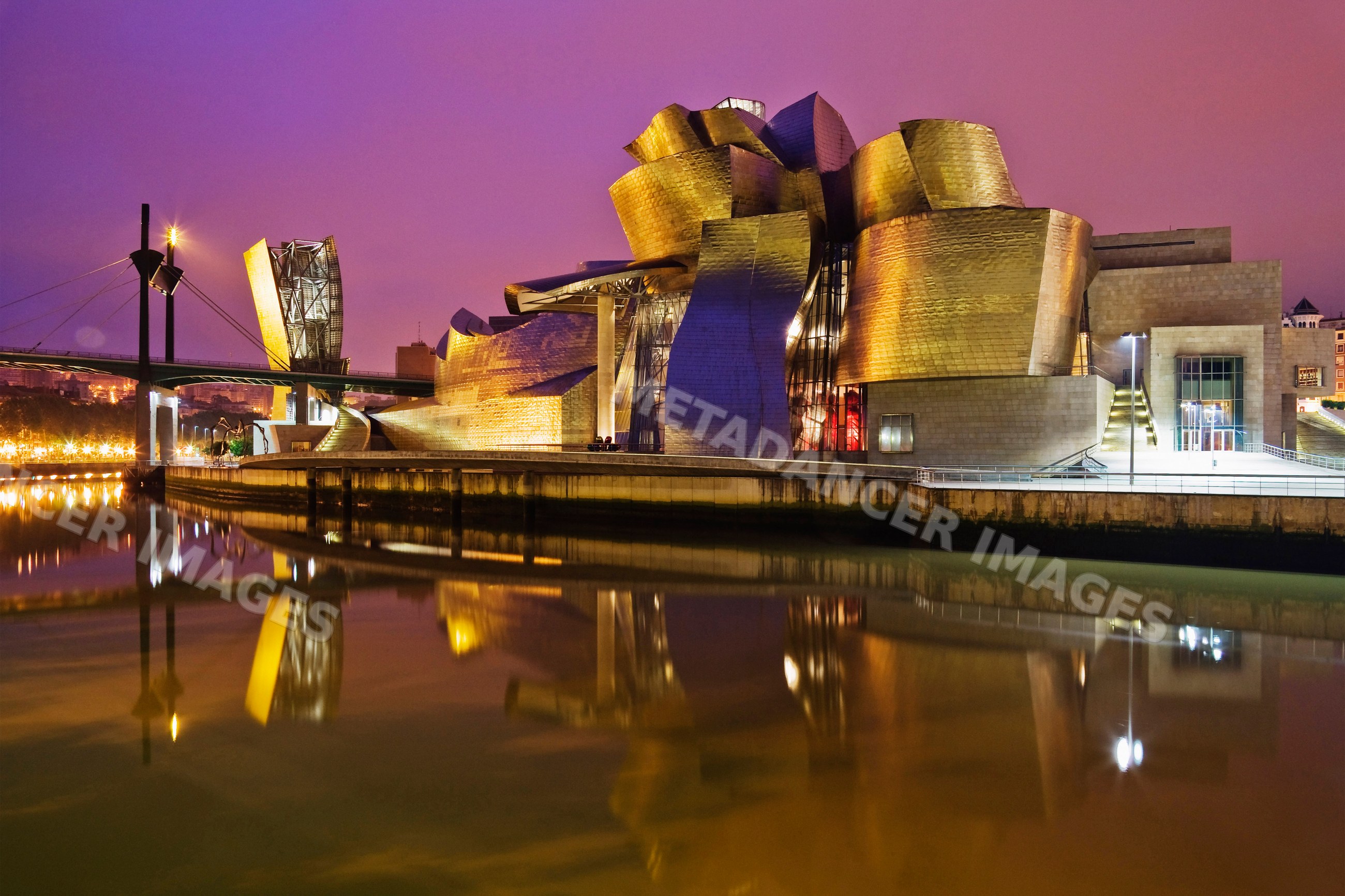 Guggenheim museum bilbao illuminated at night with river reflection