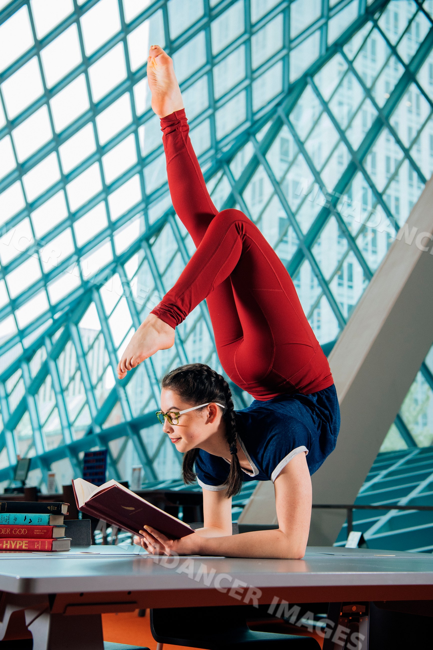 A young woman reads a book while balancing