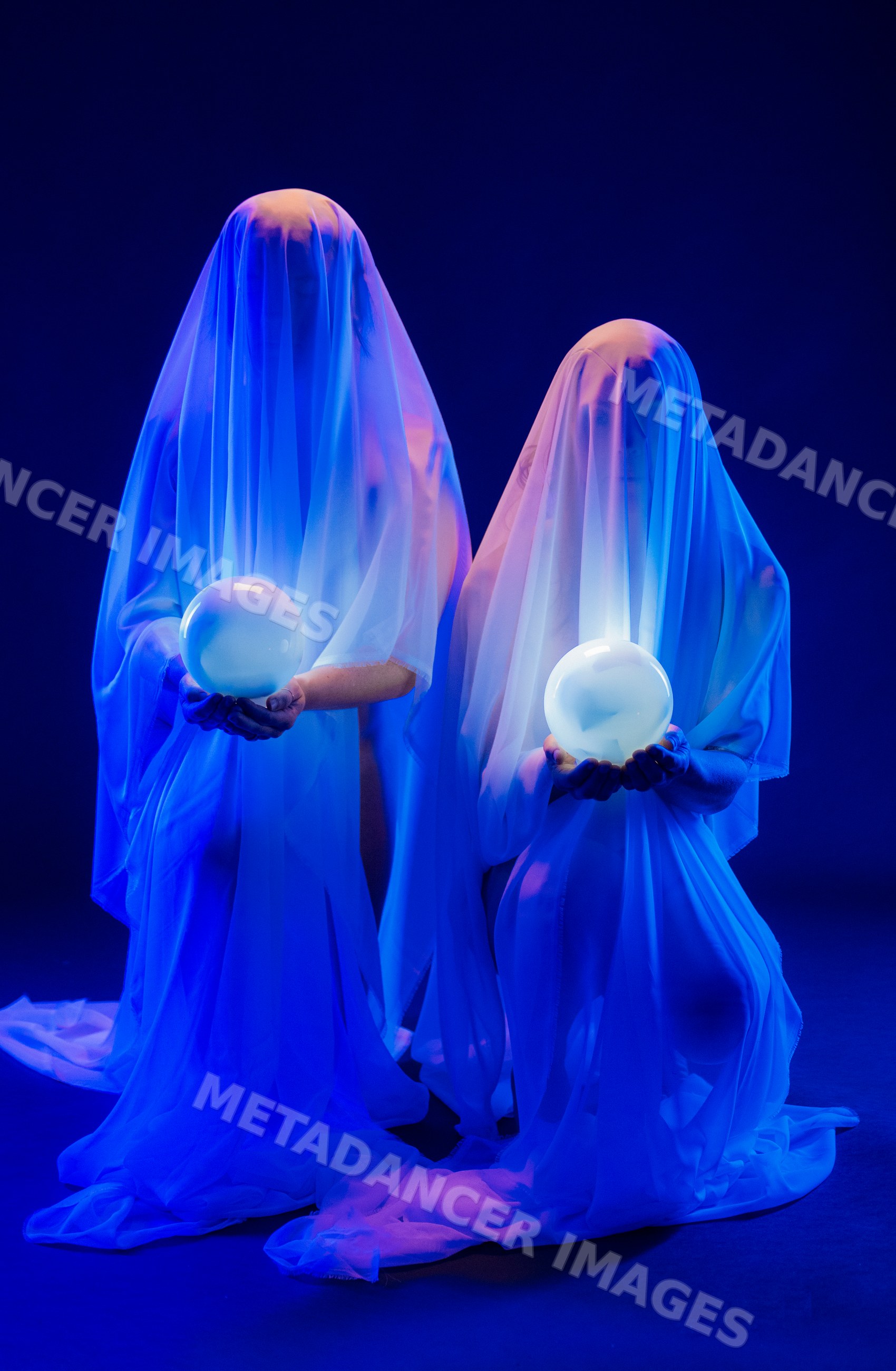 Two ghost figures holding glowing orbs under blue lighting