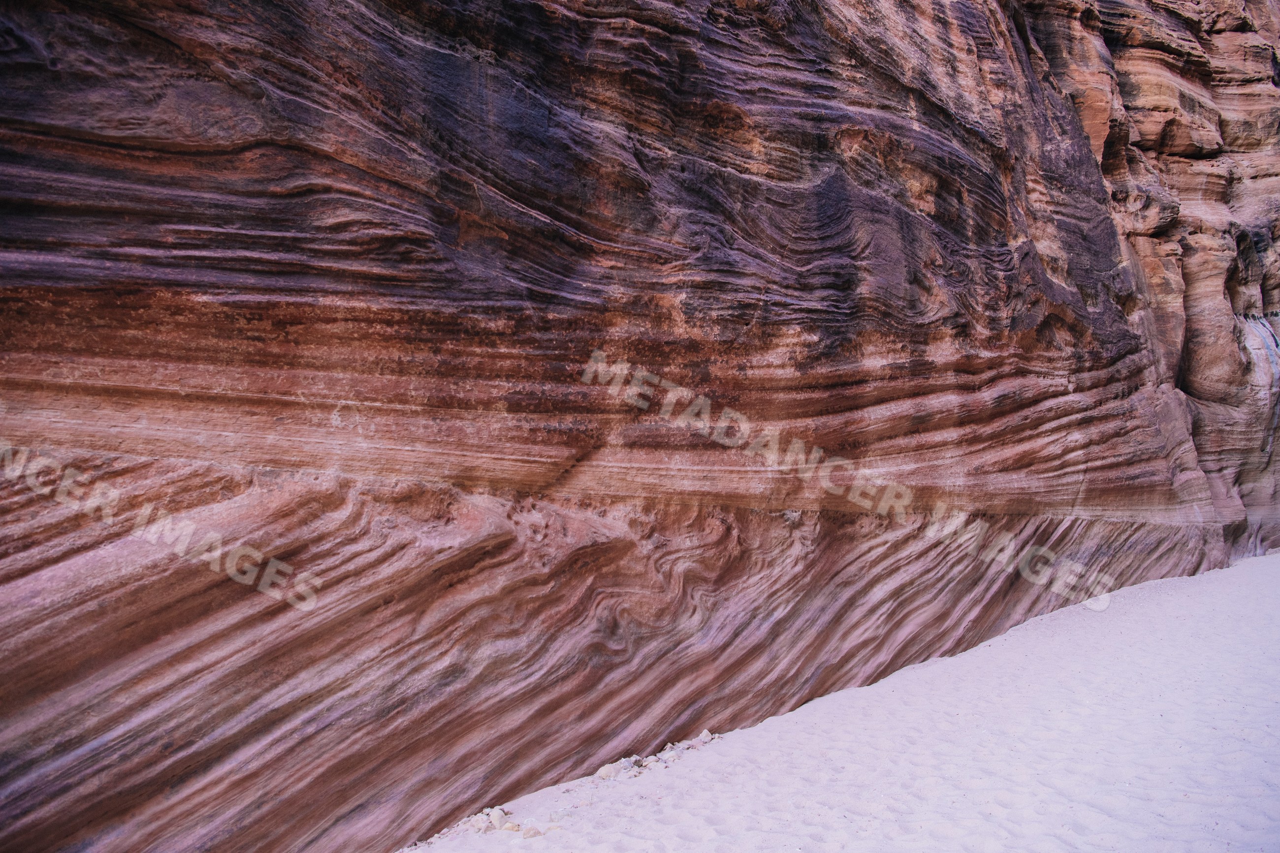 Sand and stratified rock walls slot canyon Utah