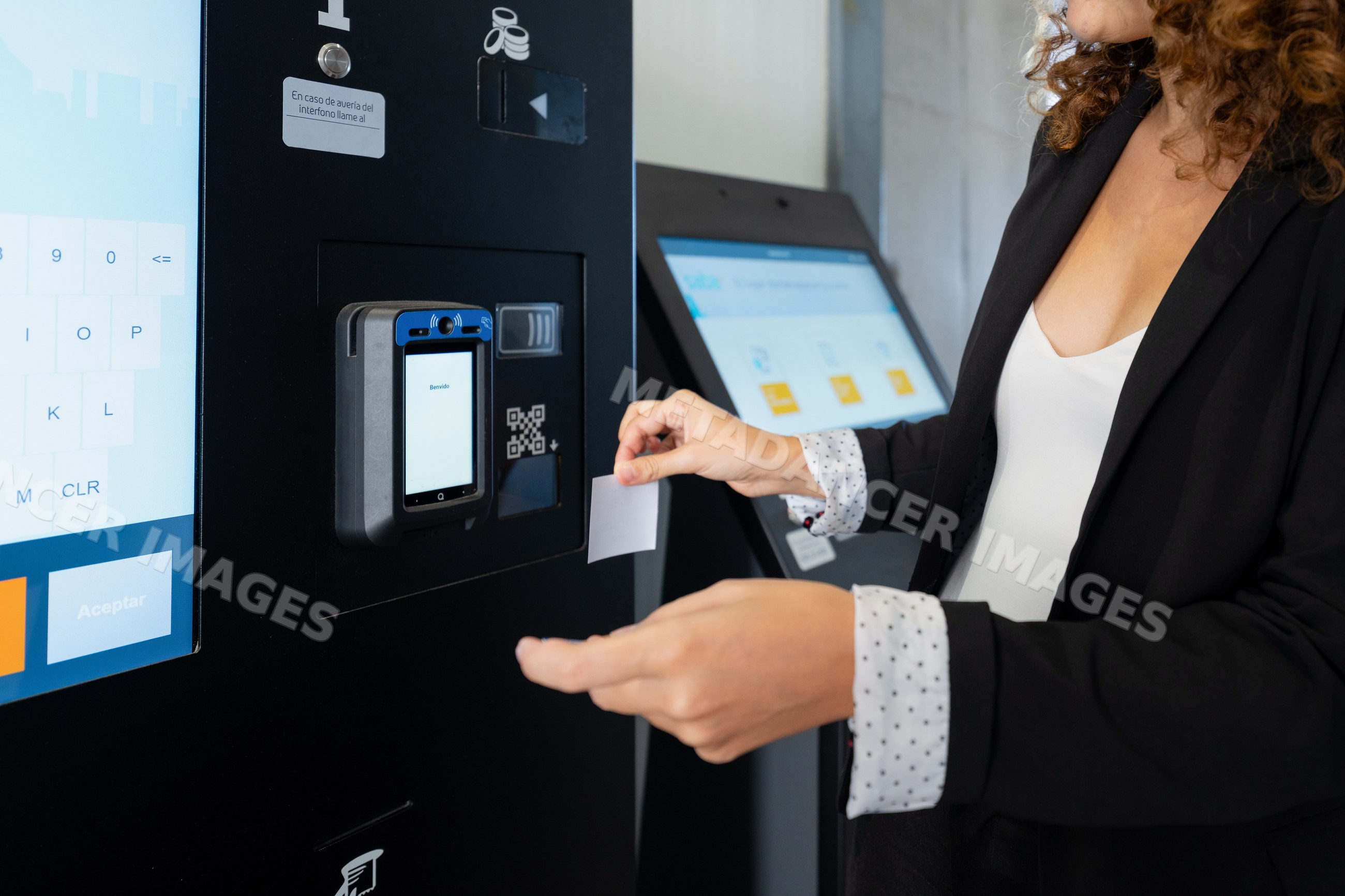 White woman collecting ticket from public transport ticket machine
