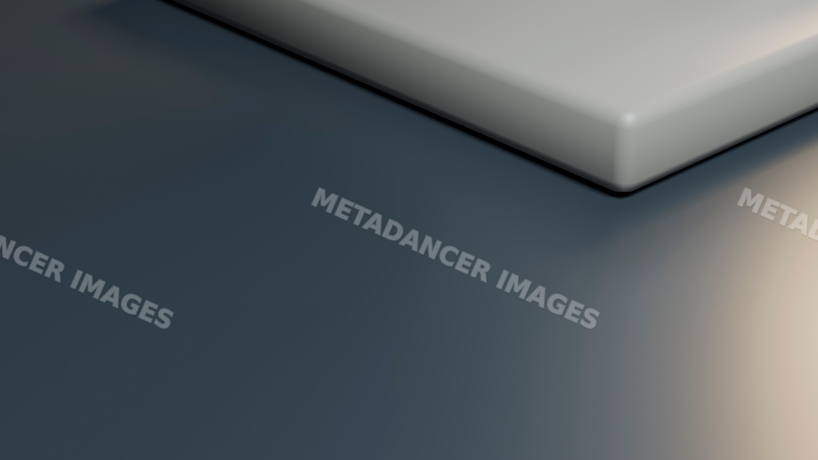 Corner of smooth rectangular object casting shadow on grey surface
