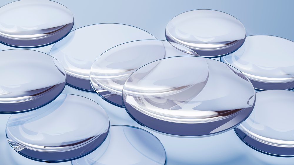 Transparent softgel capsules grouped on reflective surface