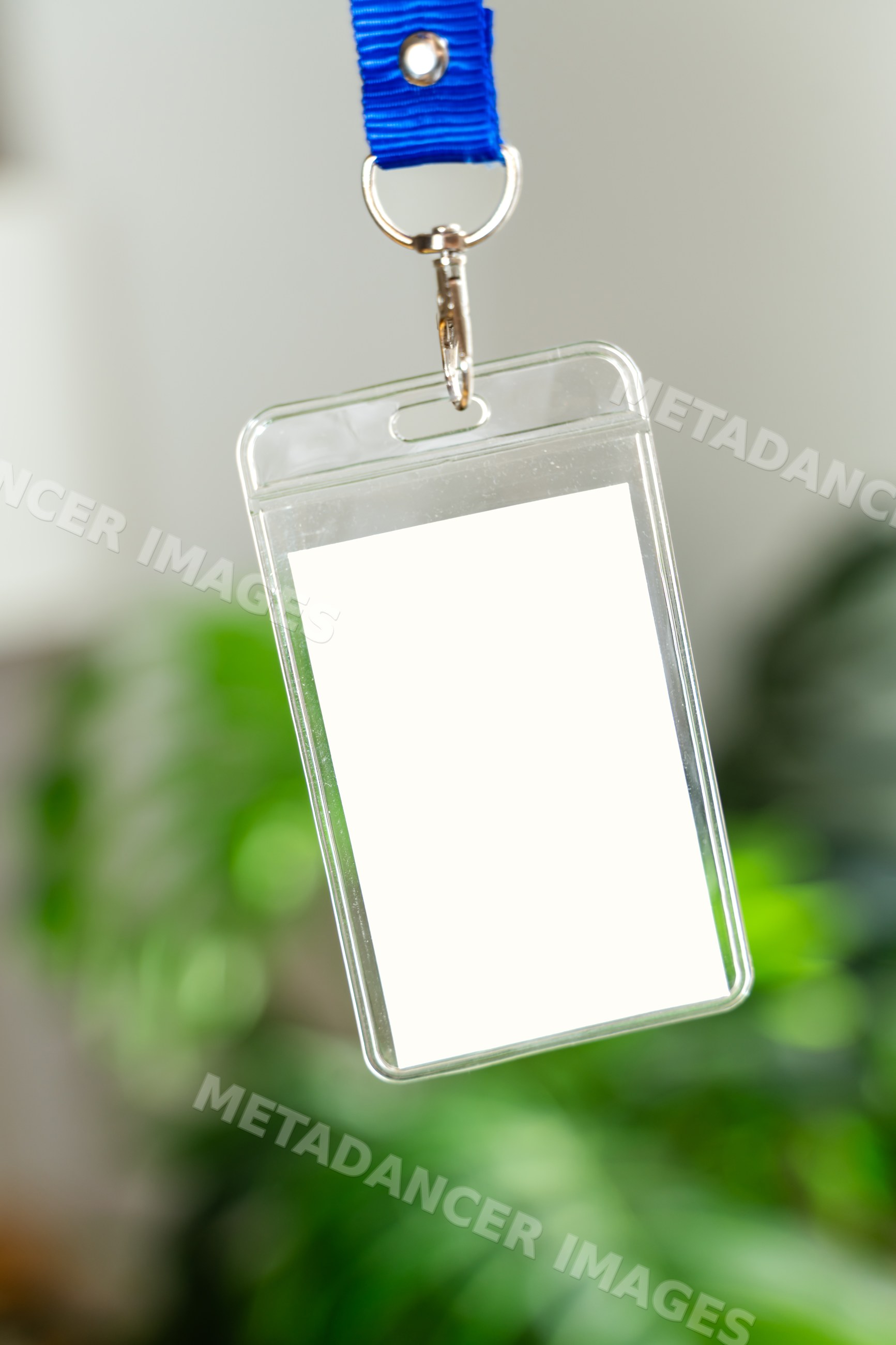 Clear plastic badge holder with blue lanyard hanging