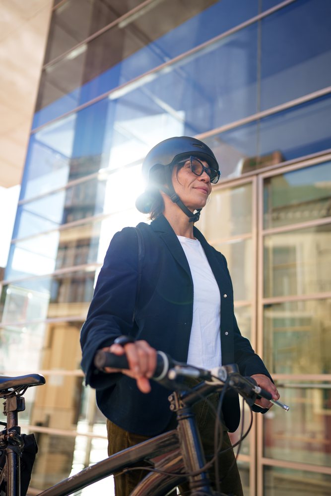 Hispanic woman wearing helmet with bicycle