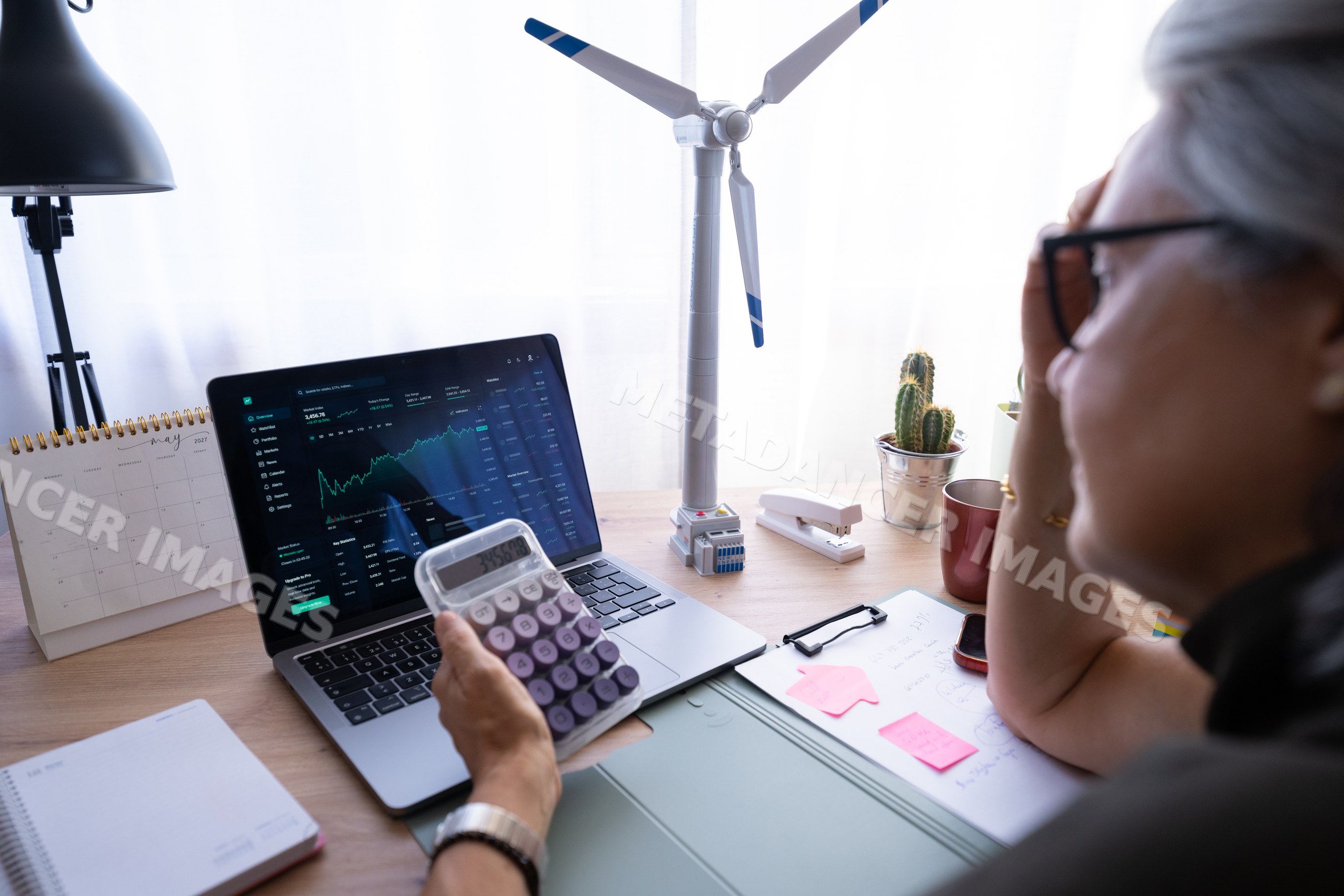 White woman analyzing financial data on laptop with calculator