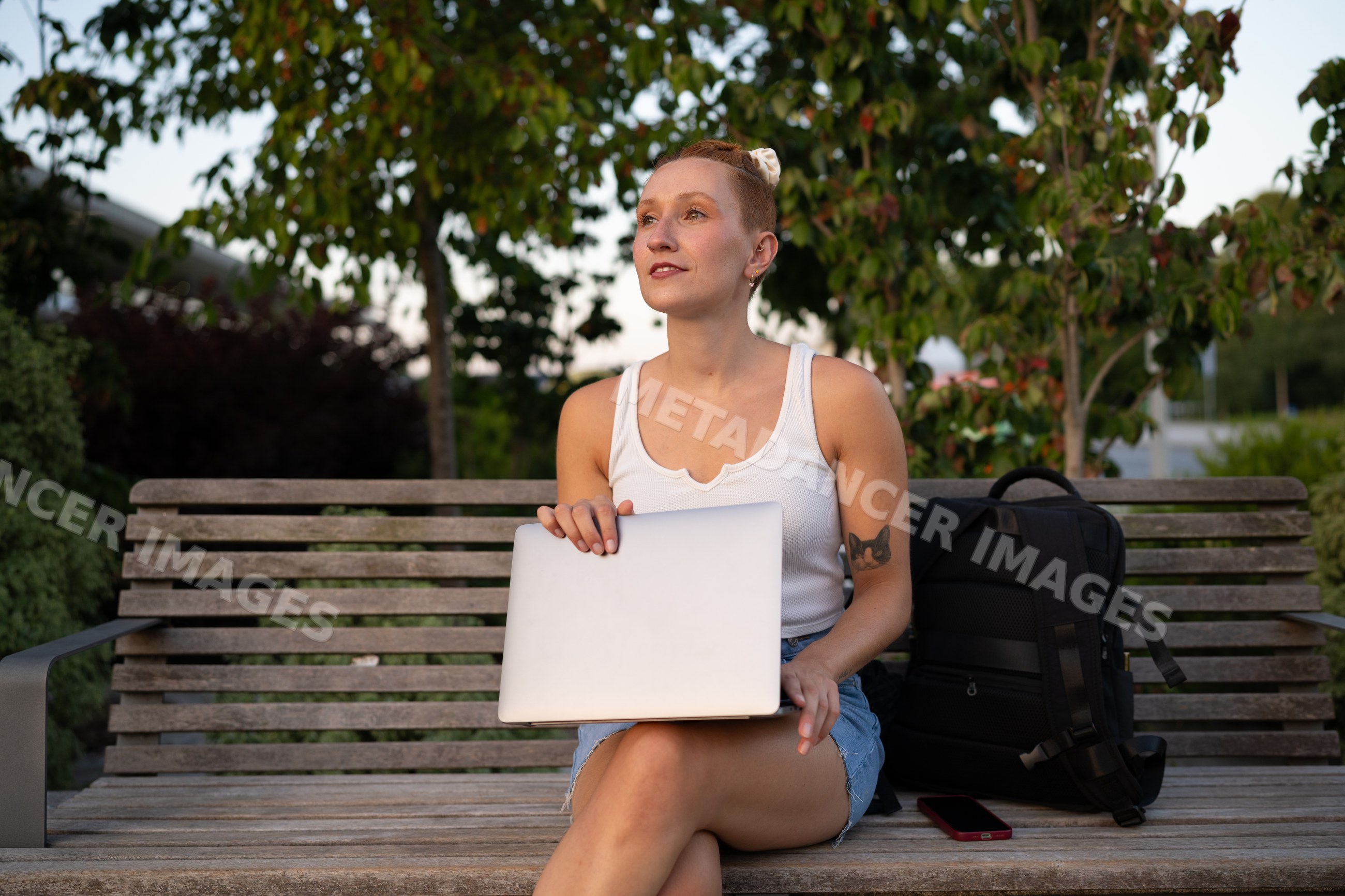 A white woman holding a laptop