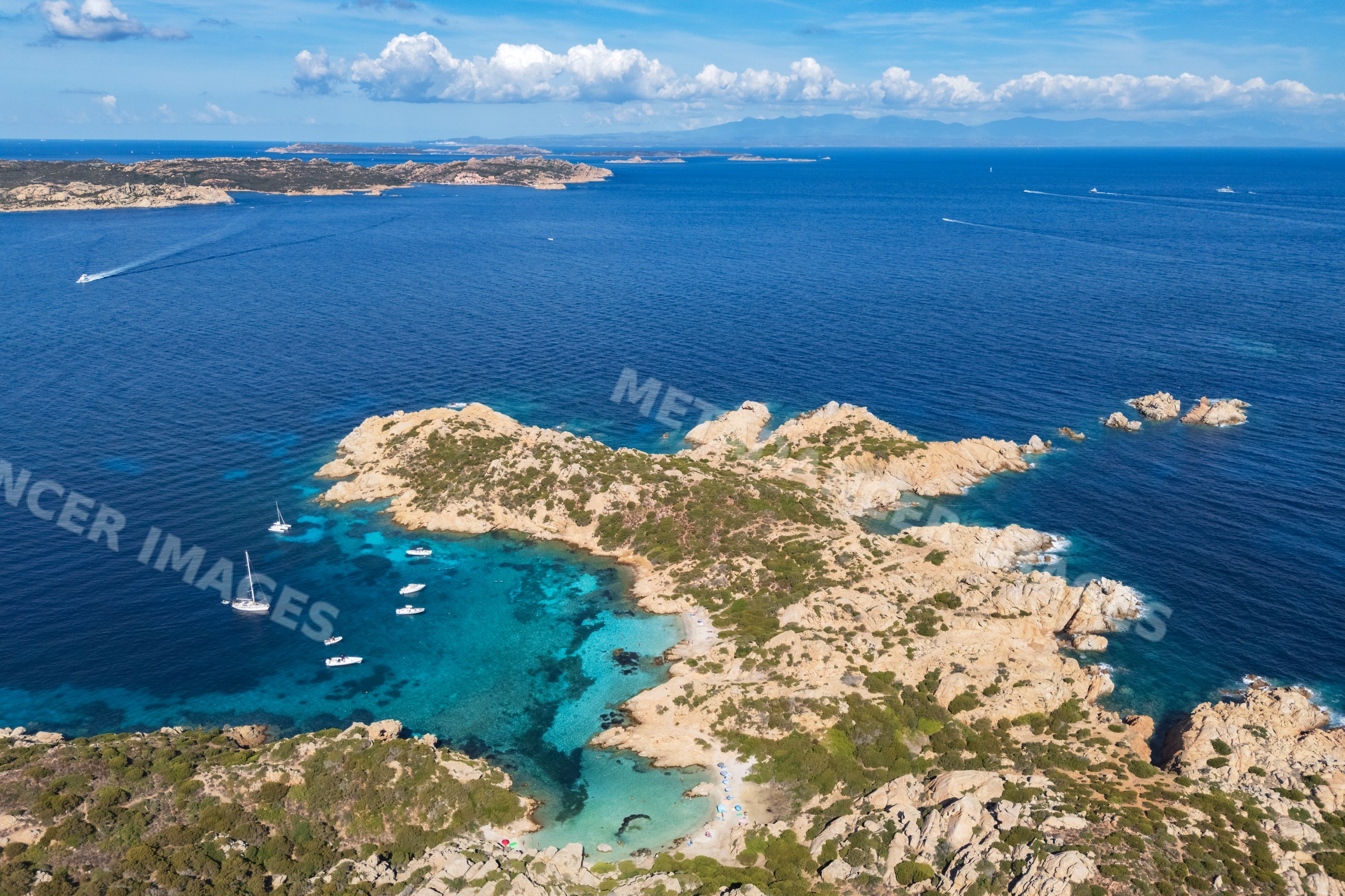 Aerial view of Cala Napolatana rocky island with sailboats