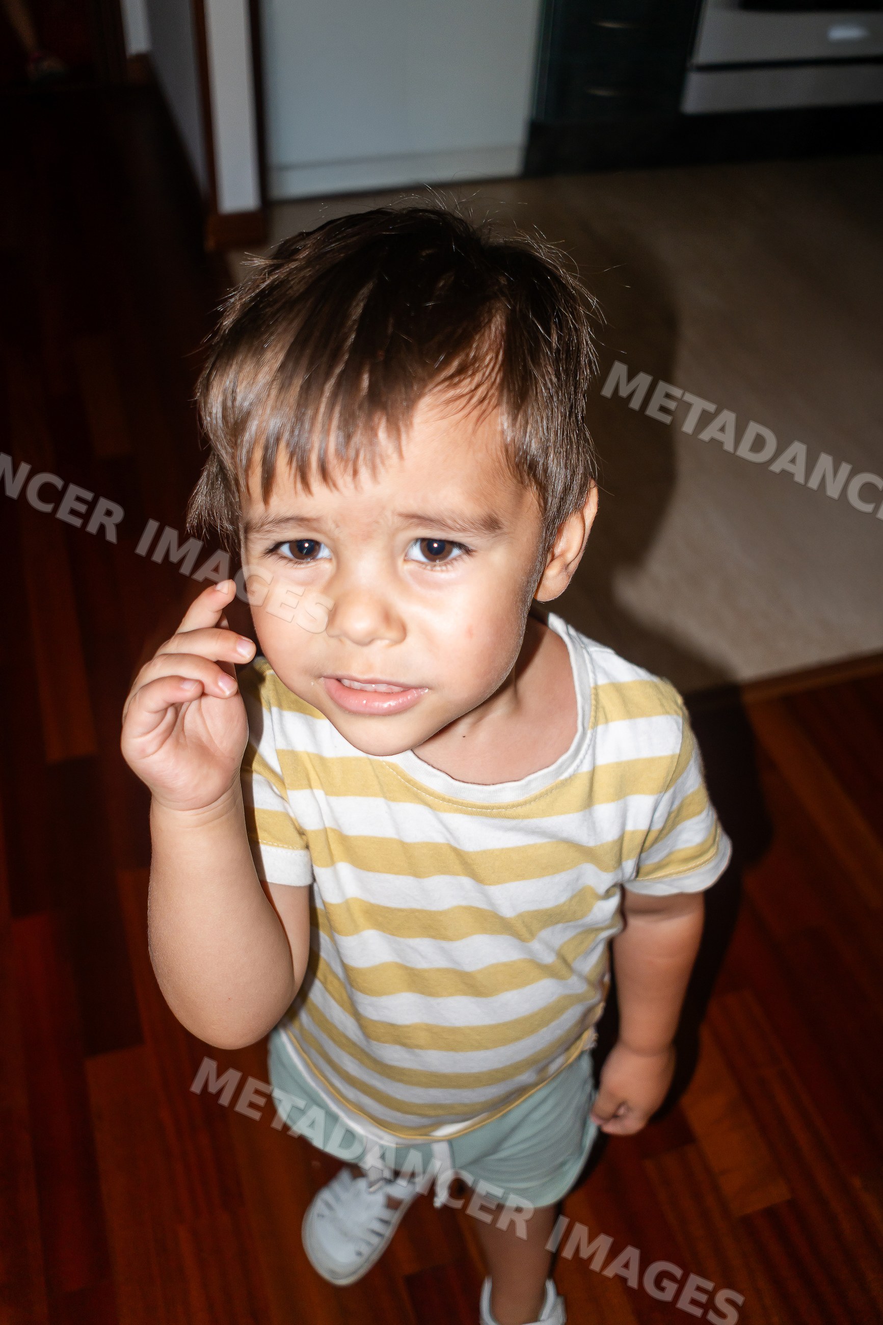 Young toddler white boy standing indoors on wooden floor