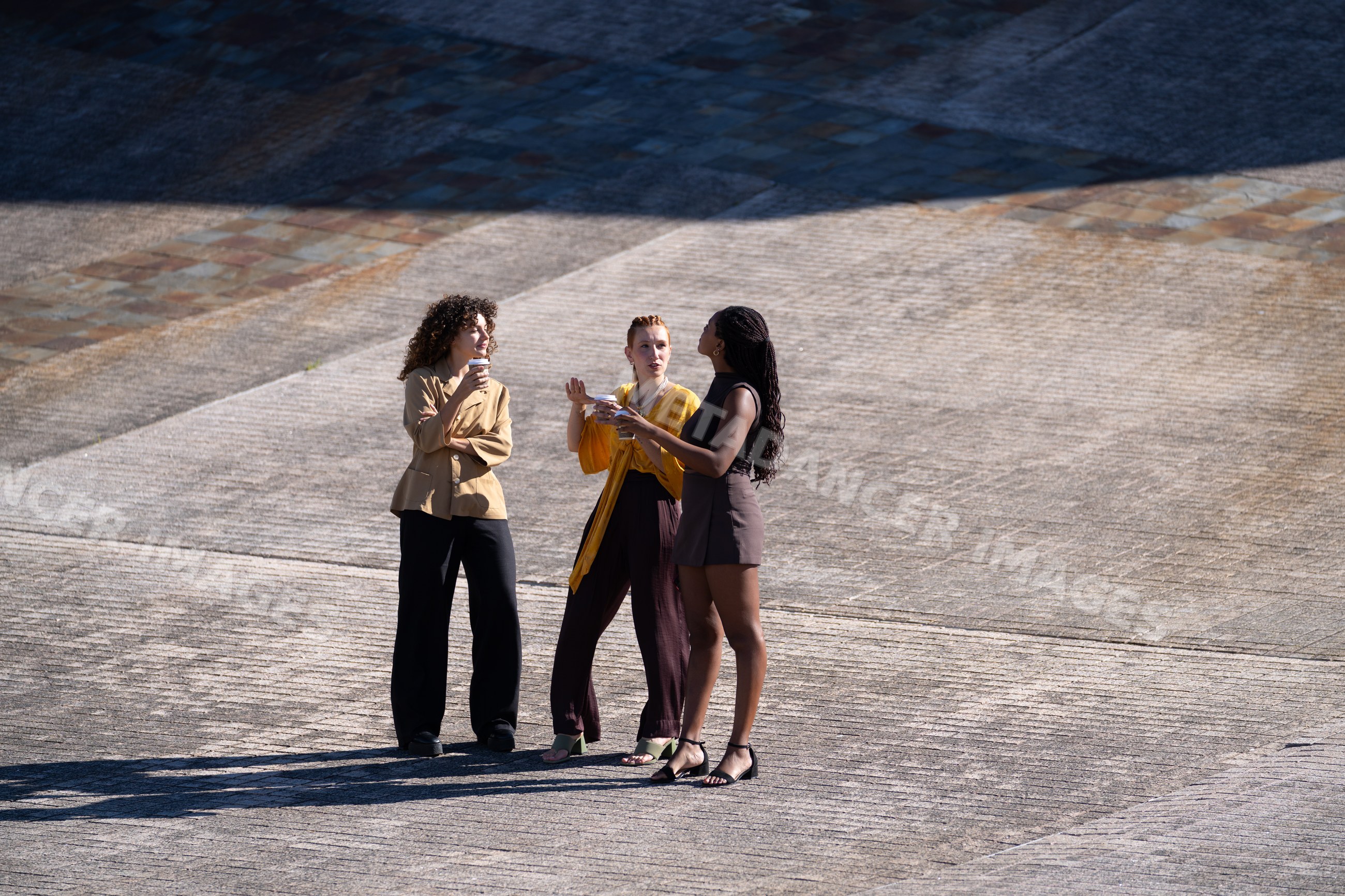 Three African American and white women drinking coffee and talking