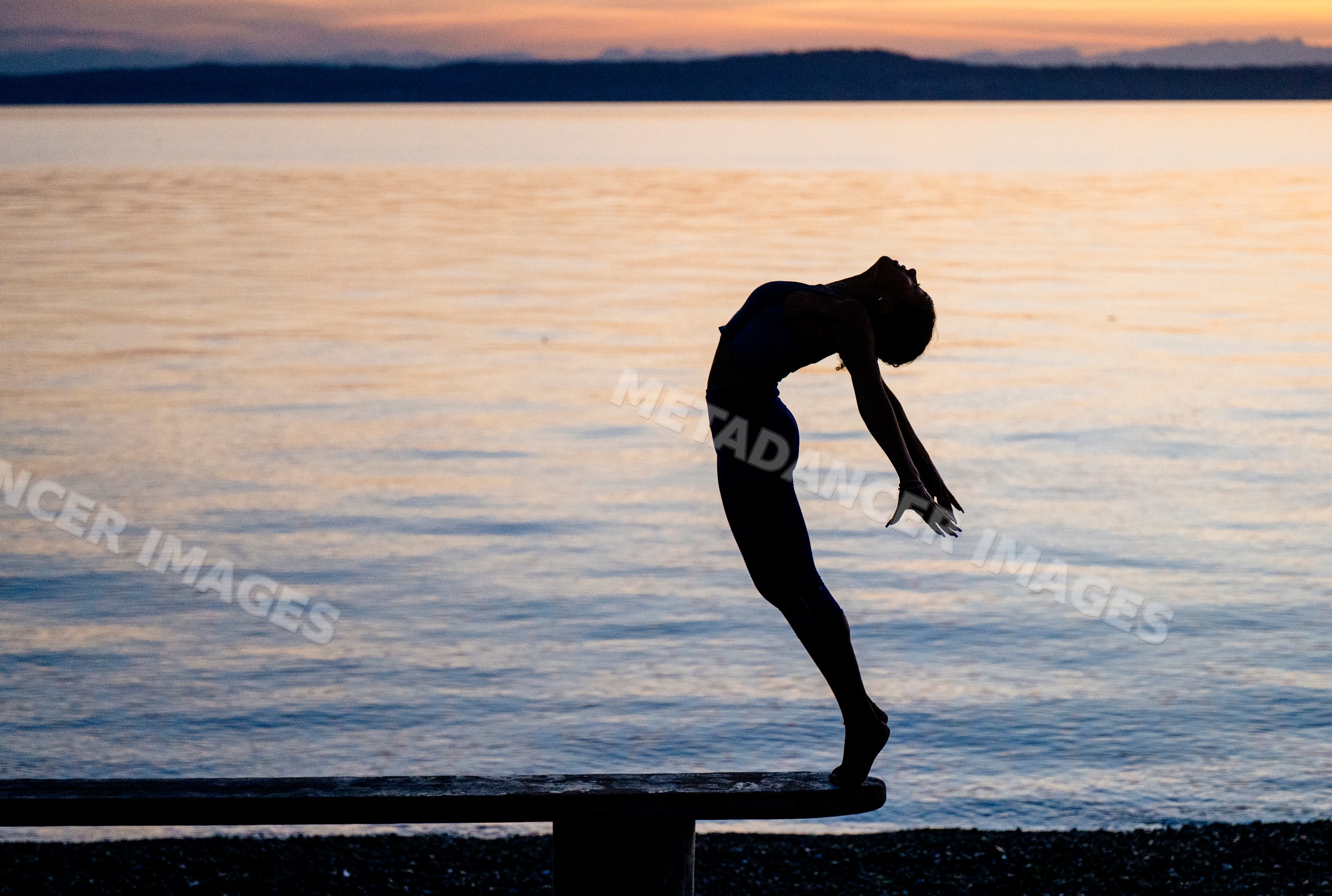 Hispanic woman performing yoga acrobatics backbend outdoors