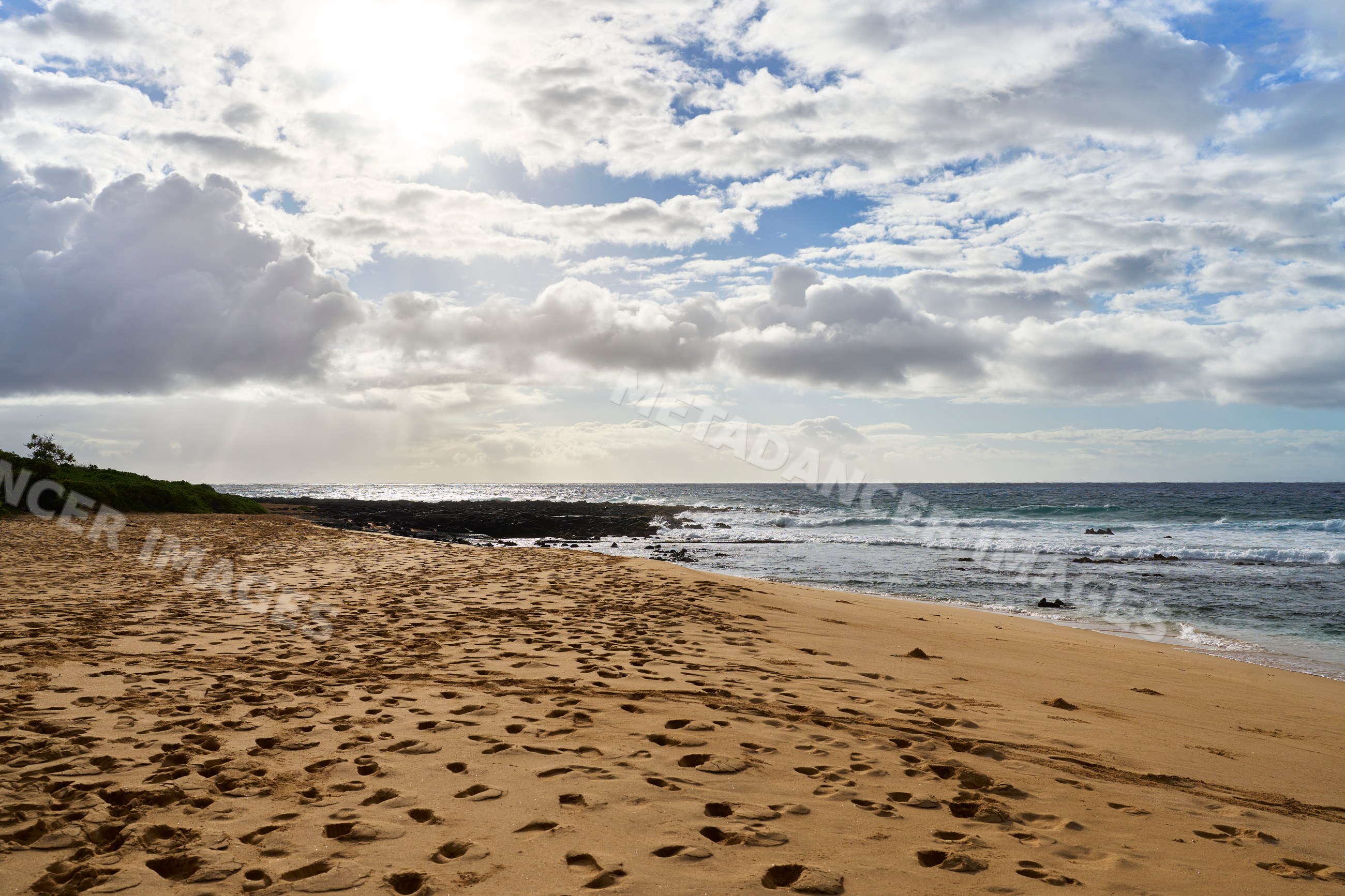 Beach with footprints and ocean waves under cloudy sky in a beach