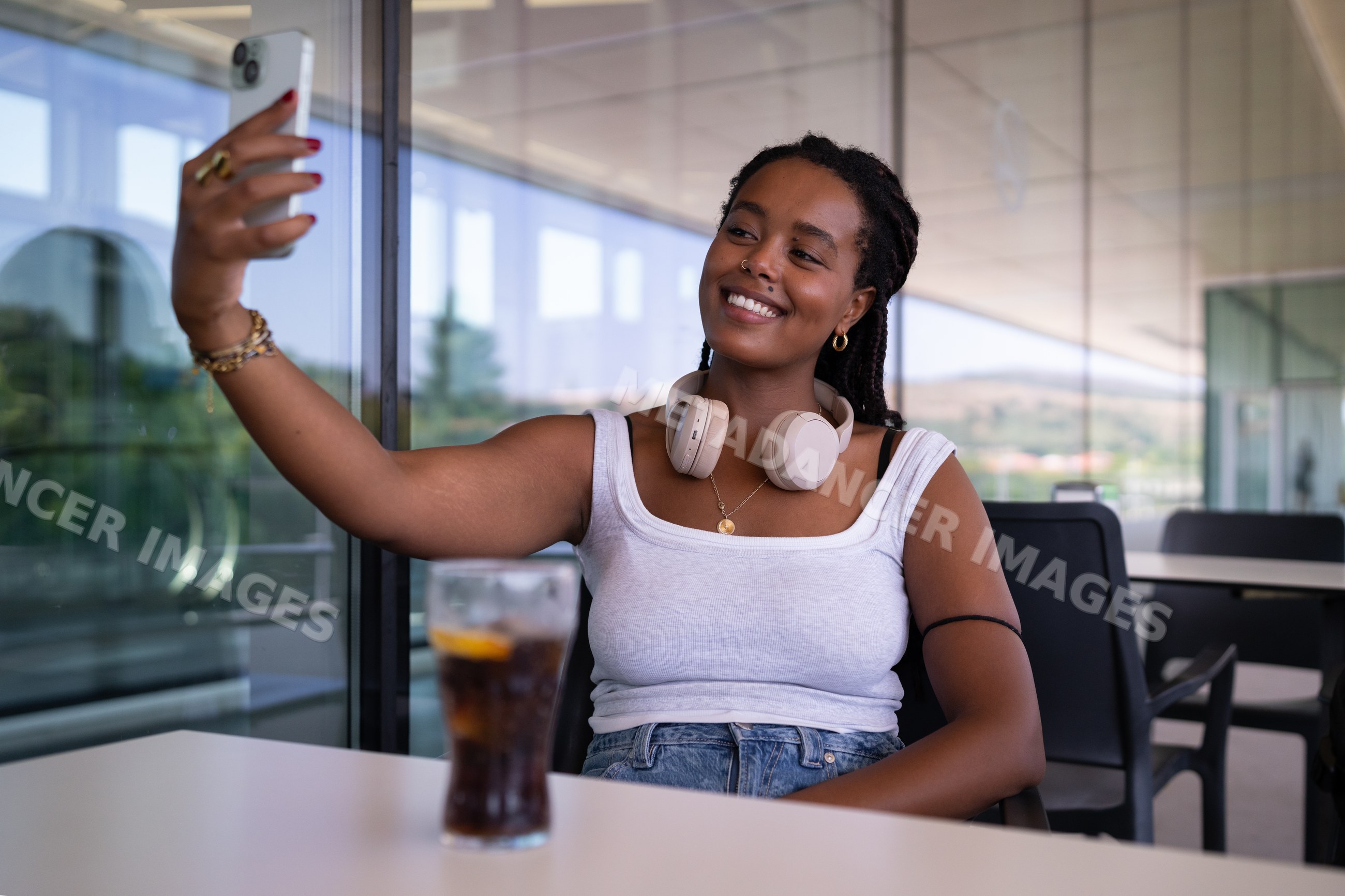 African American Woman wearing headphones takes a selfie on an outdoor