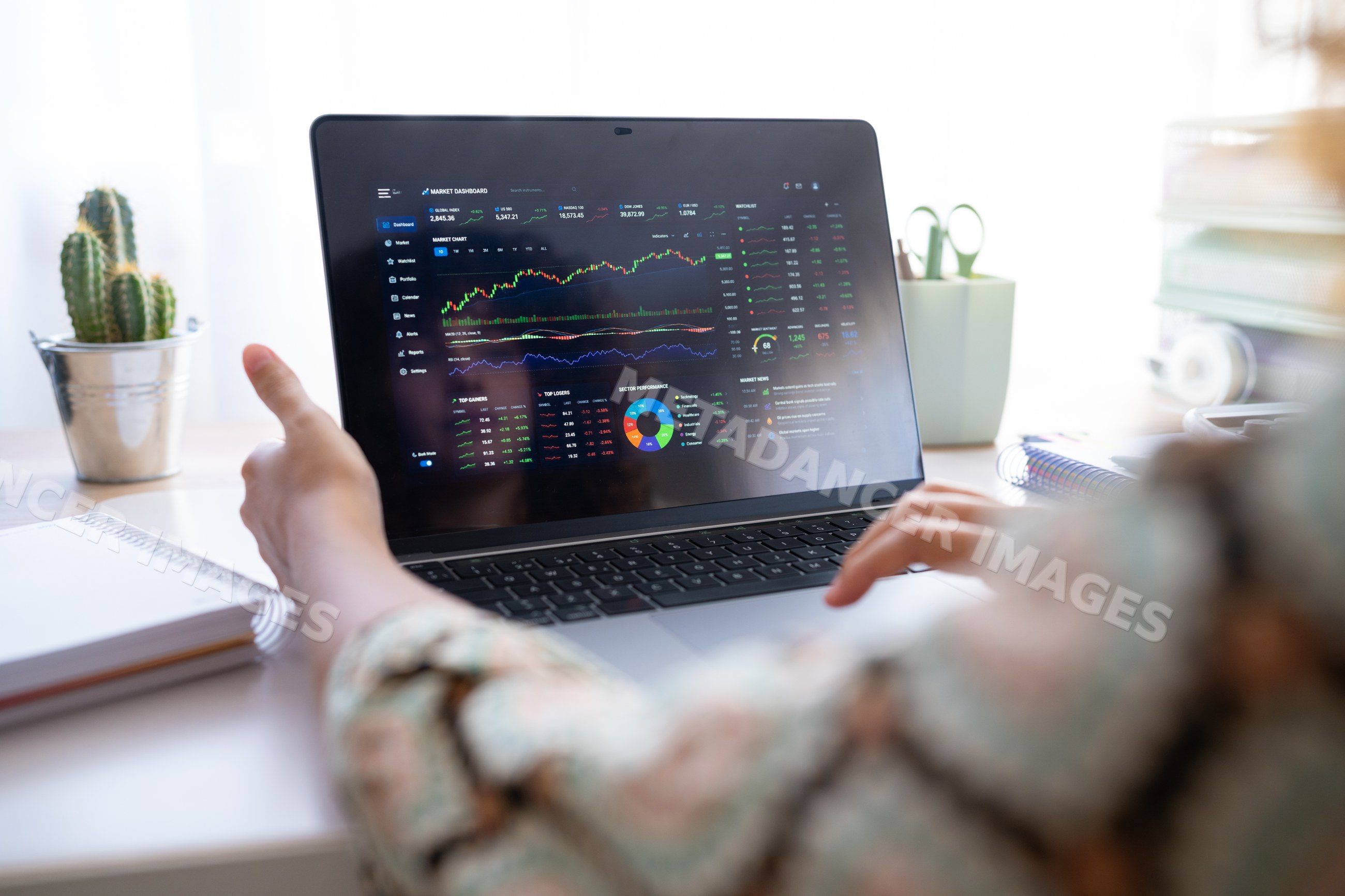 White person pointing at stock market dashboard on laptop in home