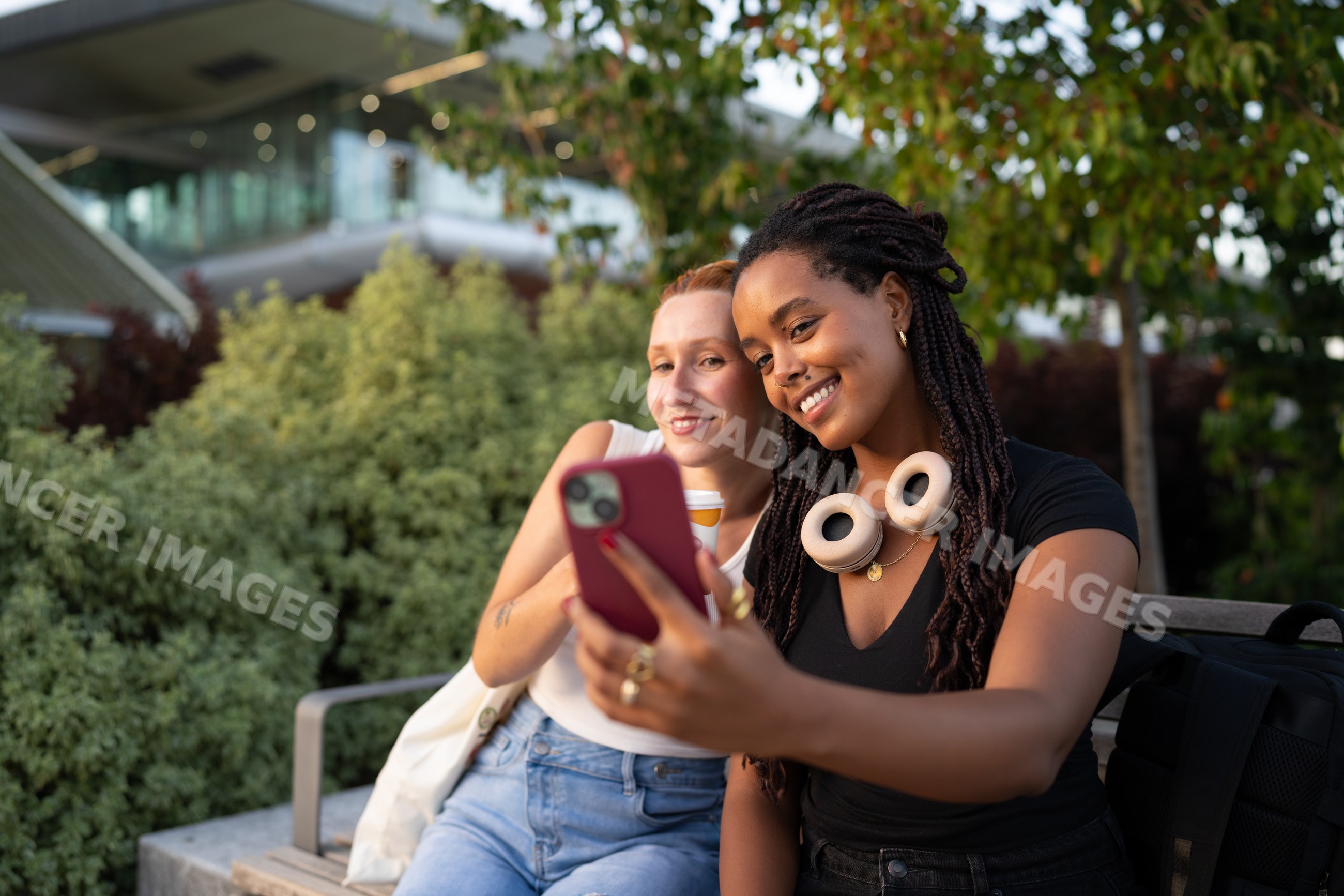 Two white and African American women taking a selfie on an outdoor