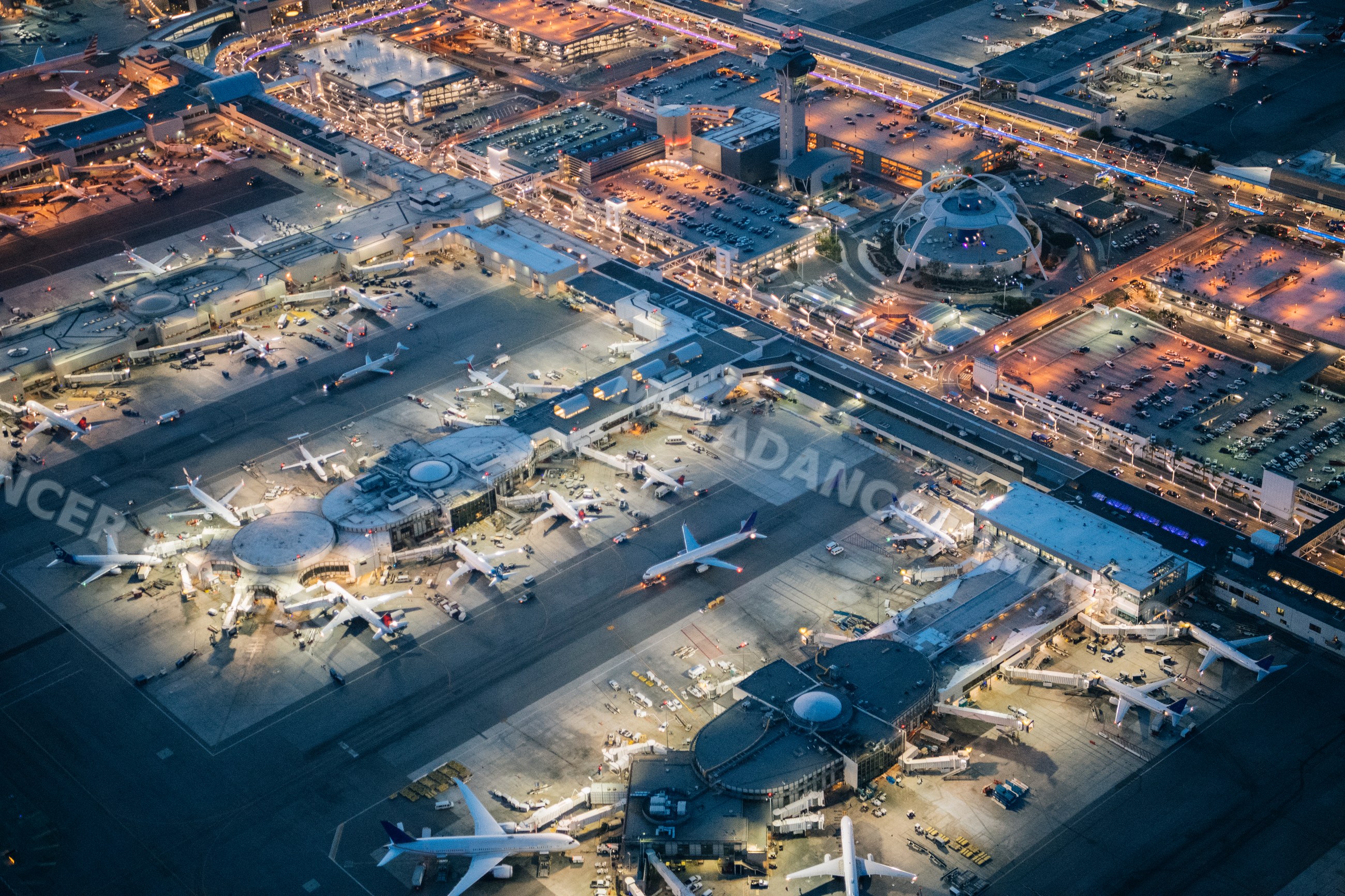 Aerial view of an airport with airplanes and terminal at dusk in Long
