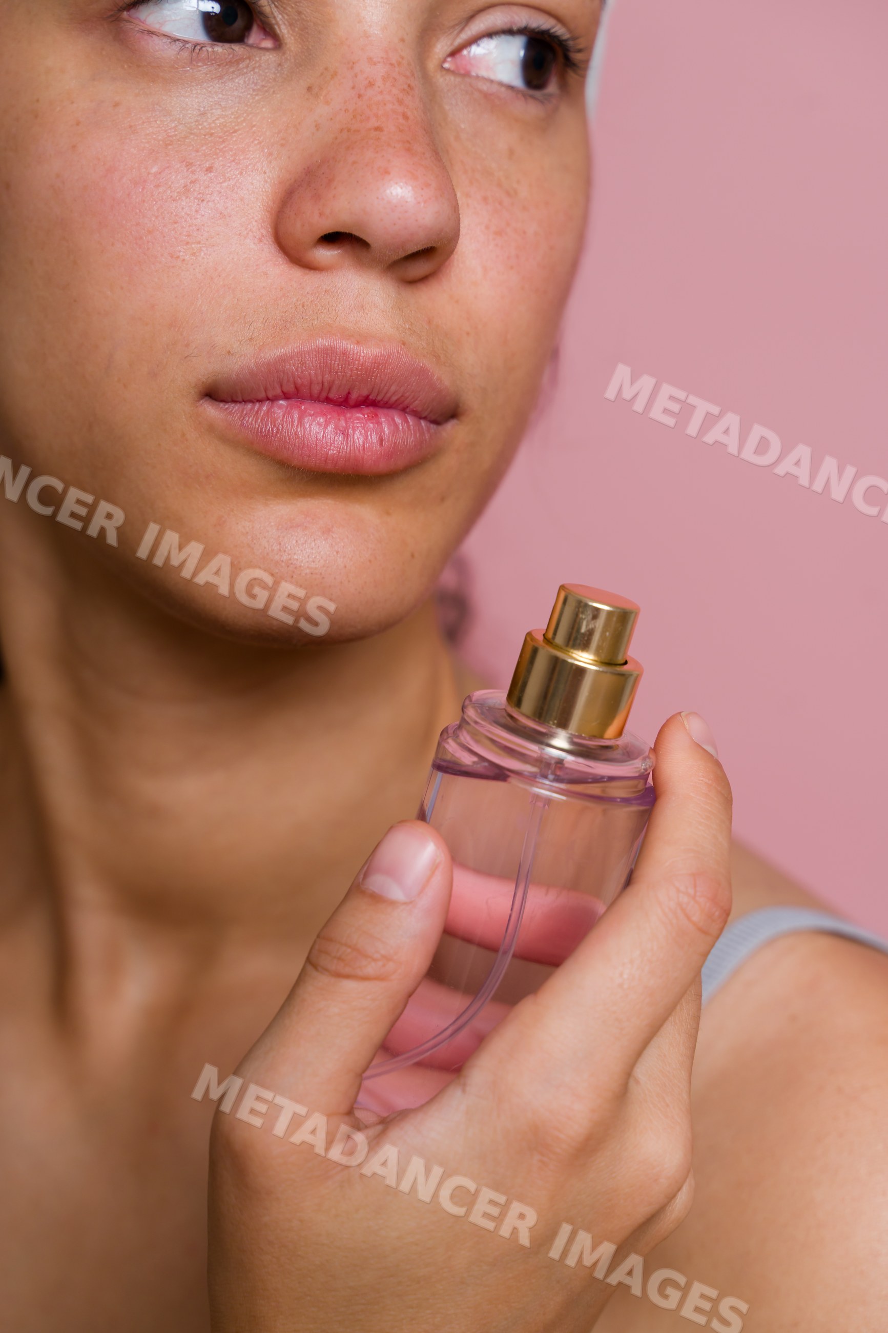 Hispanic woman holding perfume spray bottle in beauty shoot