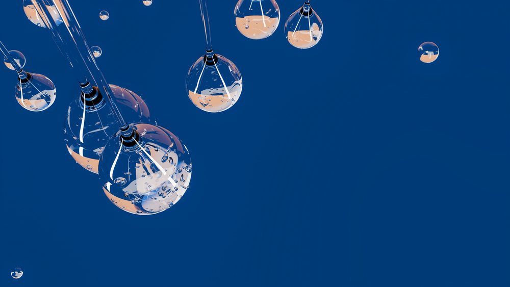 Transparent water droplets suspended against blue background