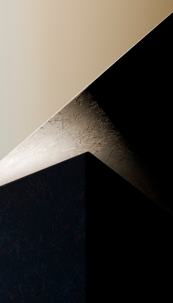 Close-up of scratched metal cube under contrasting light and shadow