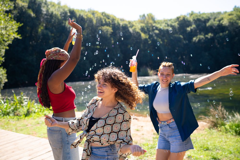 White and African American women dancing and playing with bubbles