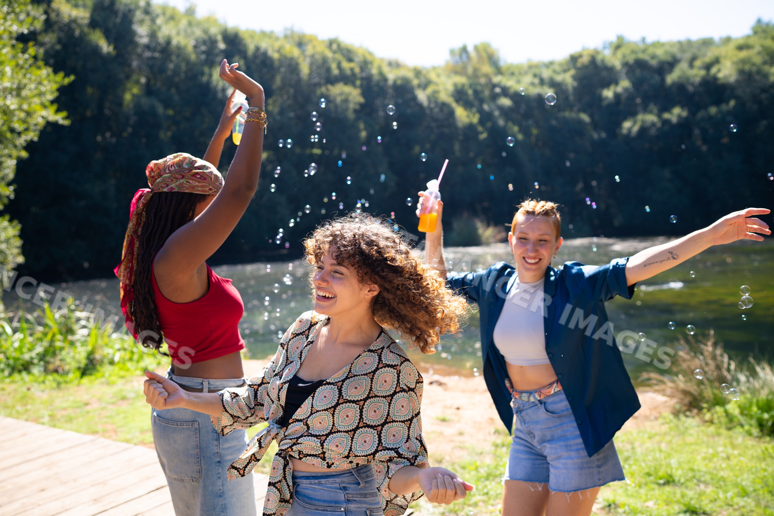 White and African American women dancing and playing with bubbles